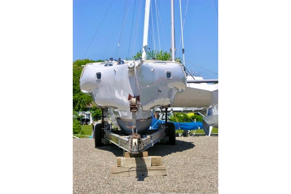 Hughes 40 sailboat from 2012 on a trailer, displayed outdoors under a clear blue sky.