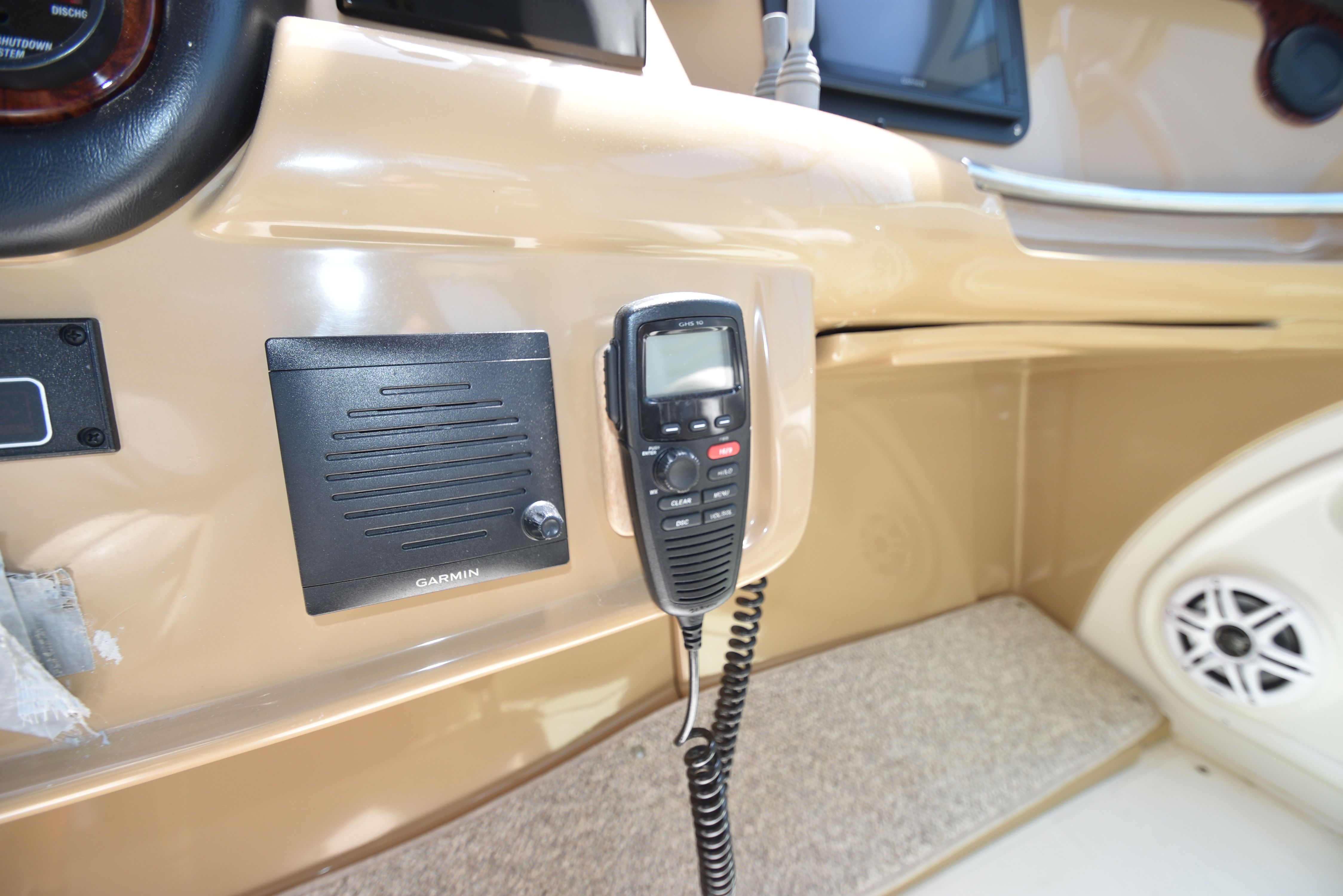 Close-up of a boat dashboard with a radio and speaker.