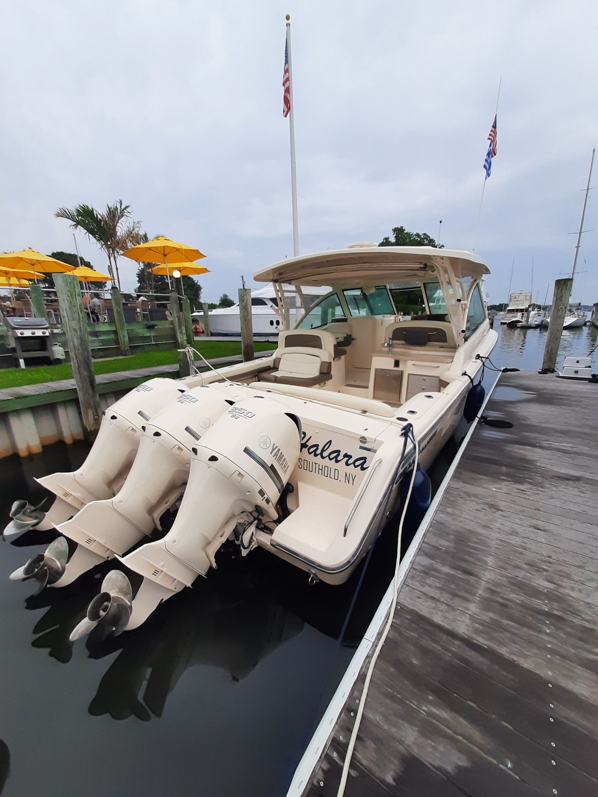A 2014 Grady-White Freedom 375 boat docked. It features three outboard engines.