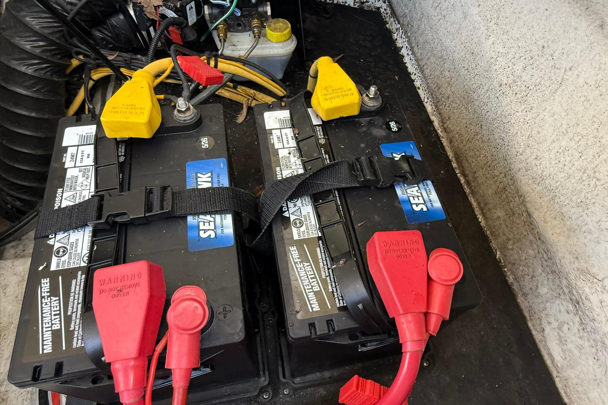 Dual marine batteries in a 2016 Crownline 255 SS boat, secured with straps.