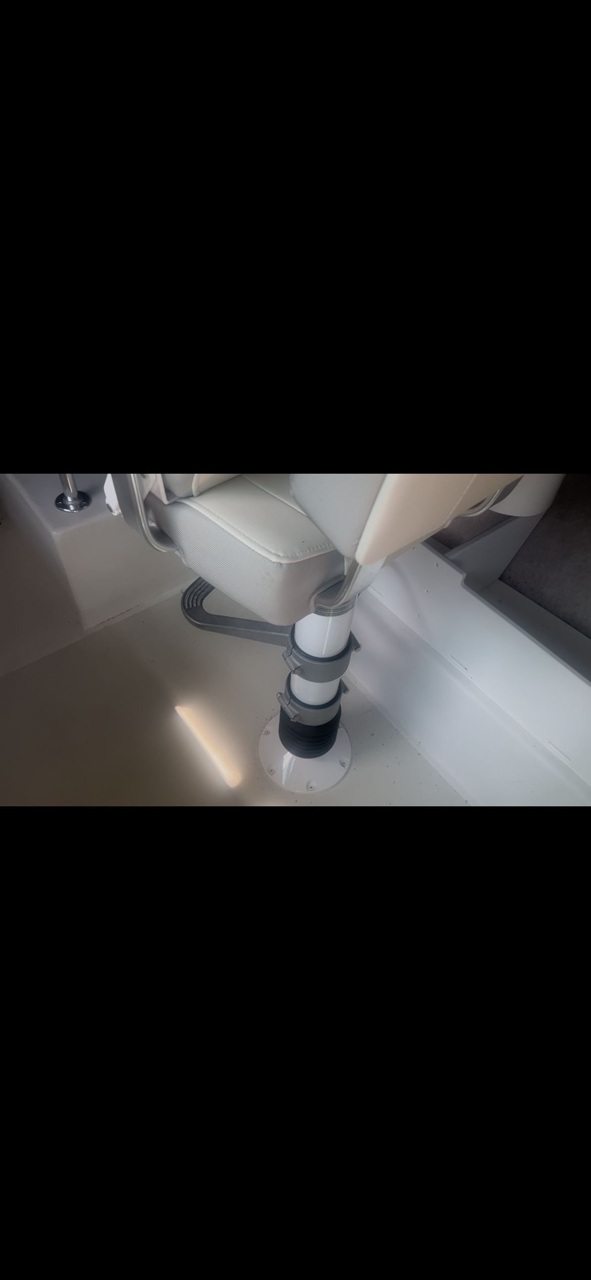 Interior view of a Parker 2320 Sport Cabin boat with a seat and pedestal.