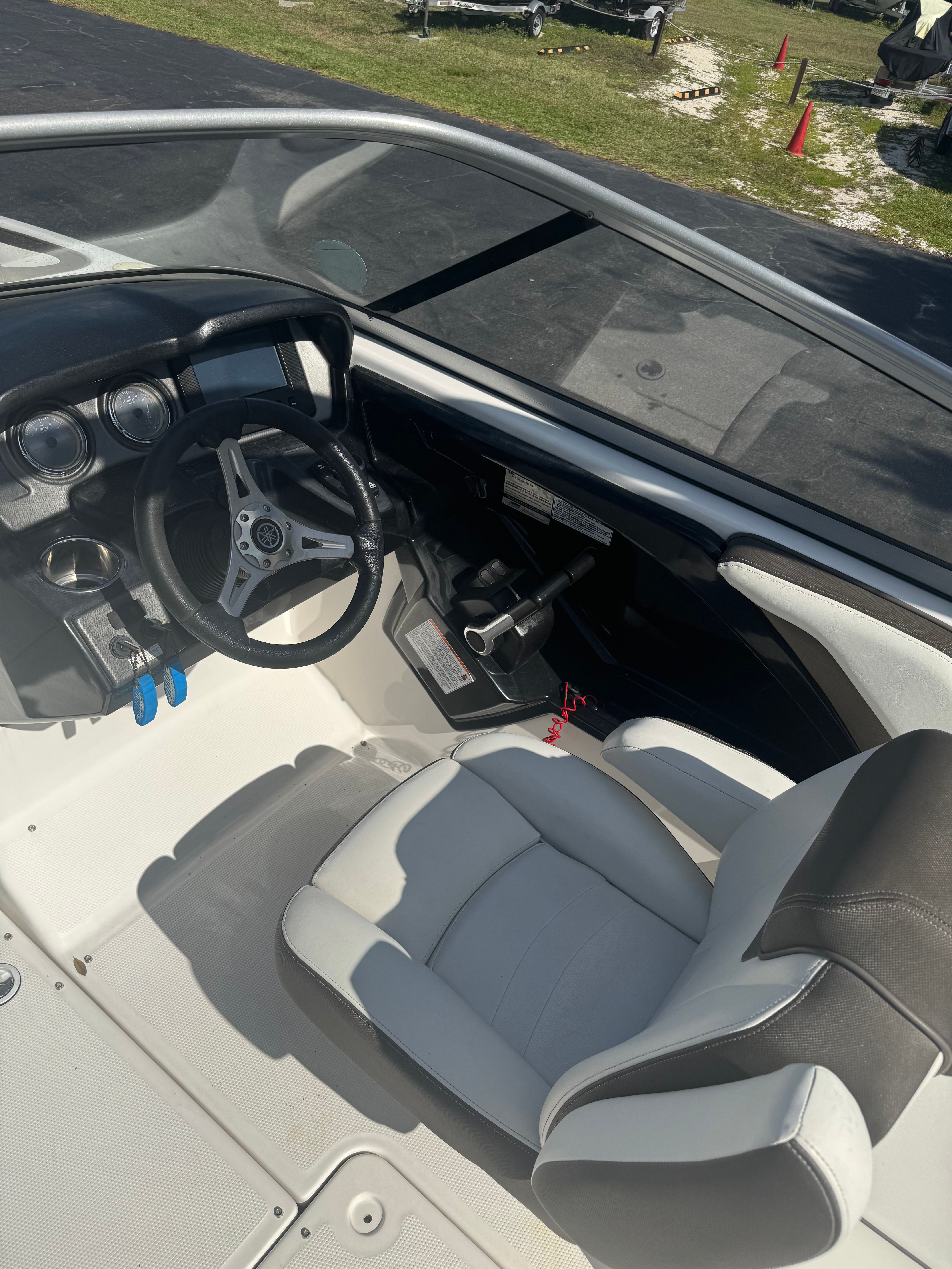 The image shows the cockpit of a 2015 Yamaha 242 Limited S boat with a sleek helm.