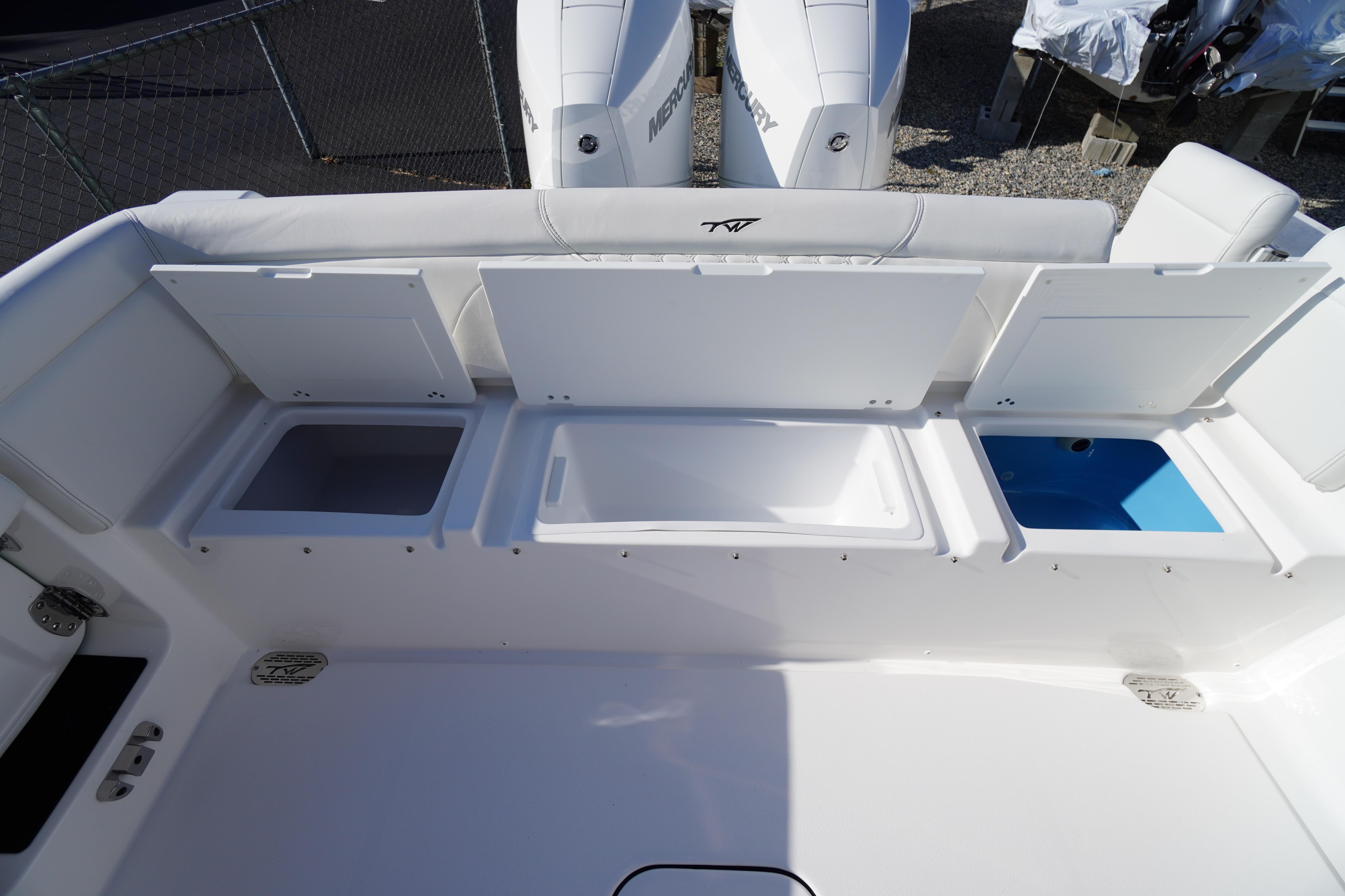 2026 Tidewater 272 LXF boat with open storage compartments and dual Mercury engines.