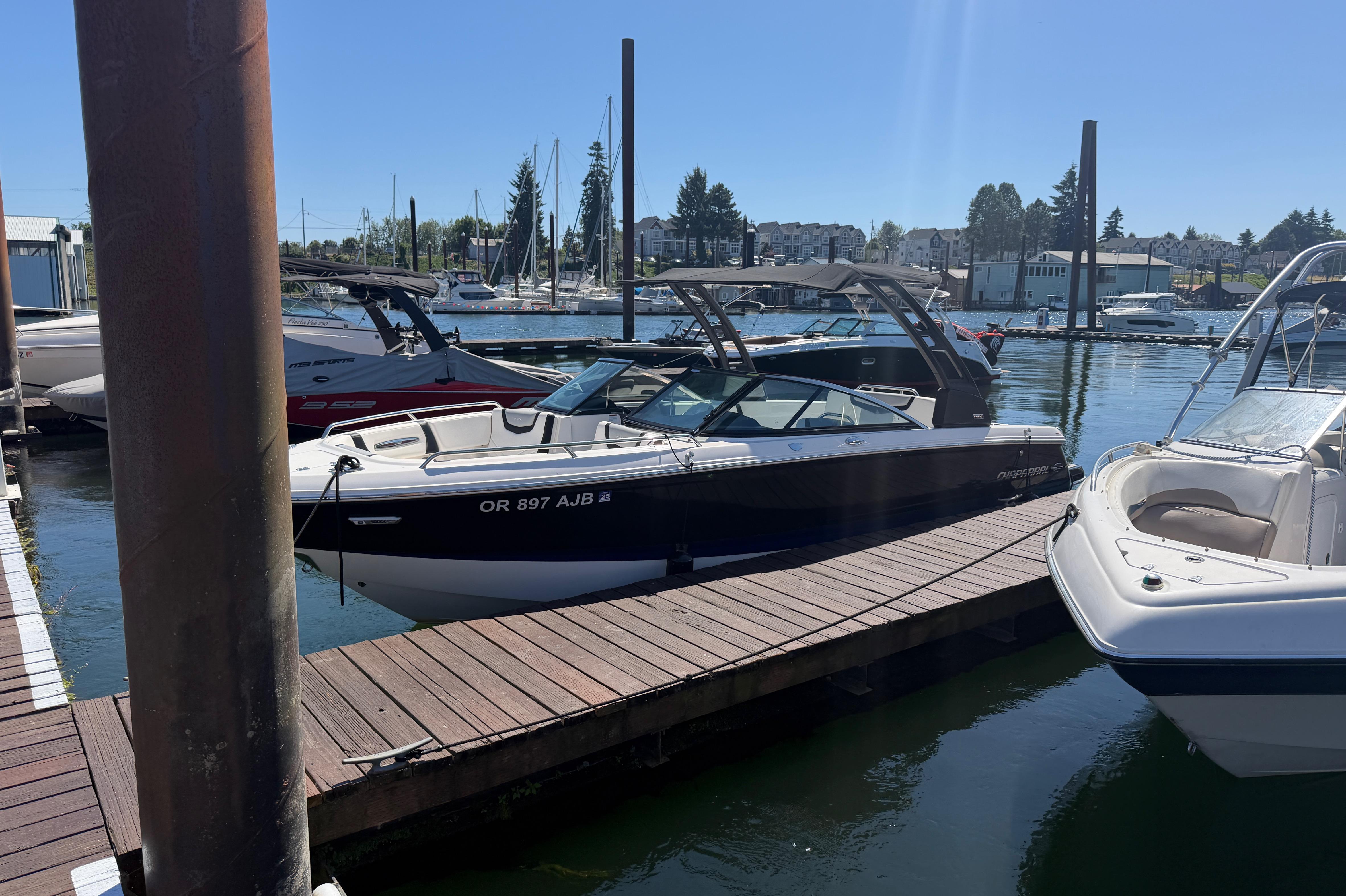 2023 Chaparral 247 SSX boat docked at a marina on a sunny day.