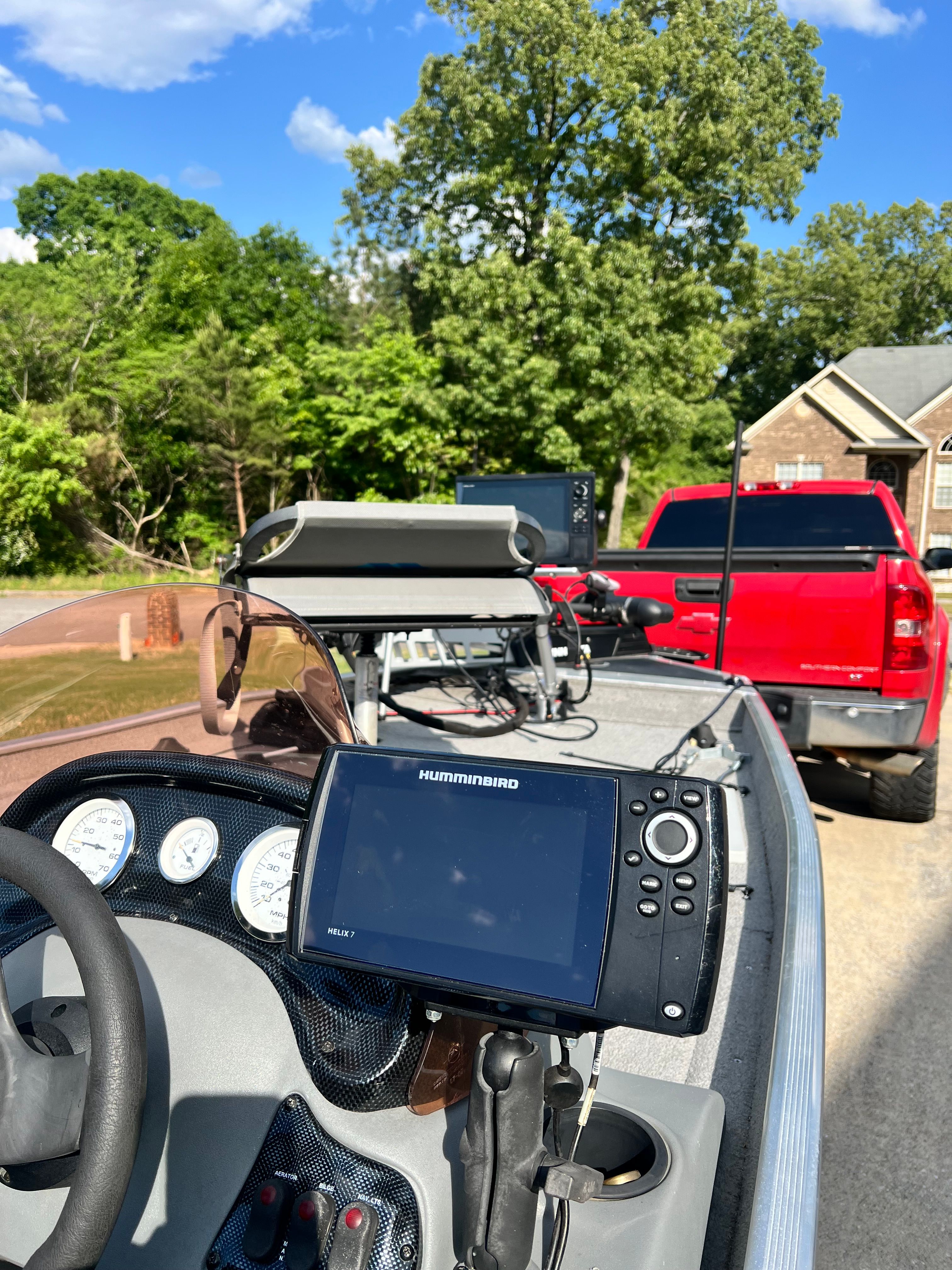 2007 Bass Tracker Pro 170 with Humminbird fish finder, parked next to red truck.