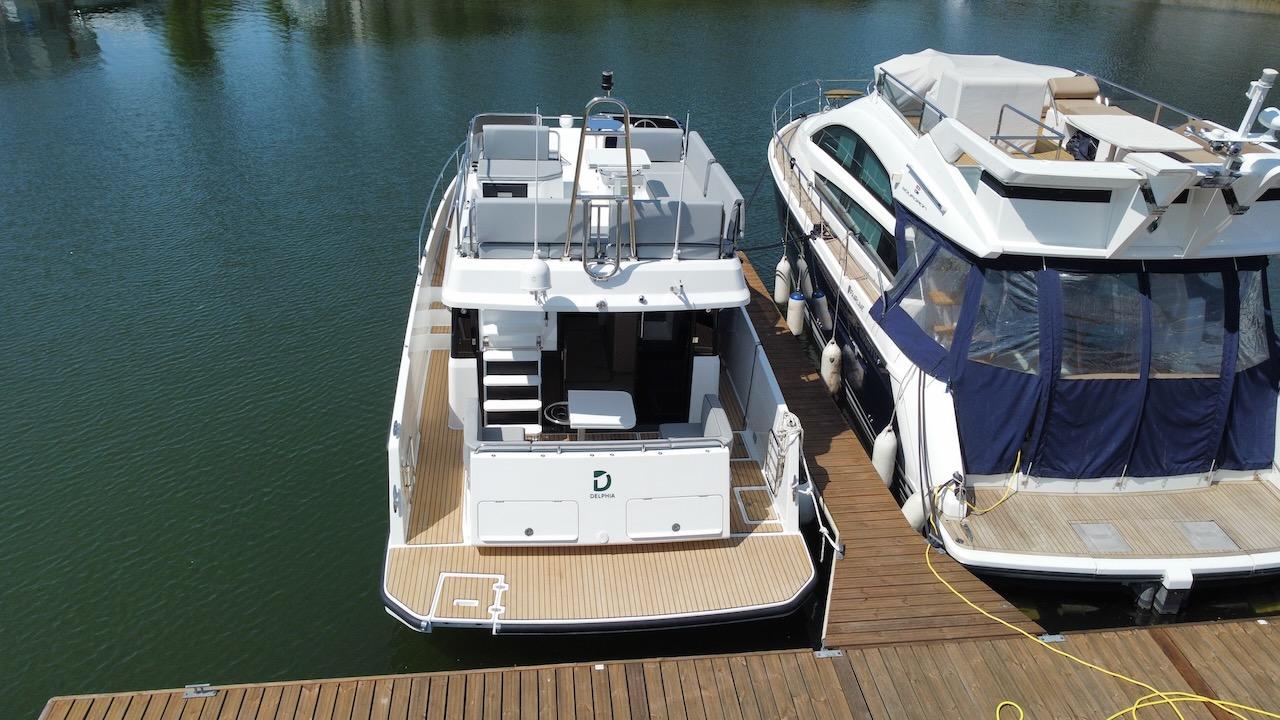 2023 Delphia 11 Flylounge yacht docked at marina, rear view.