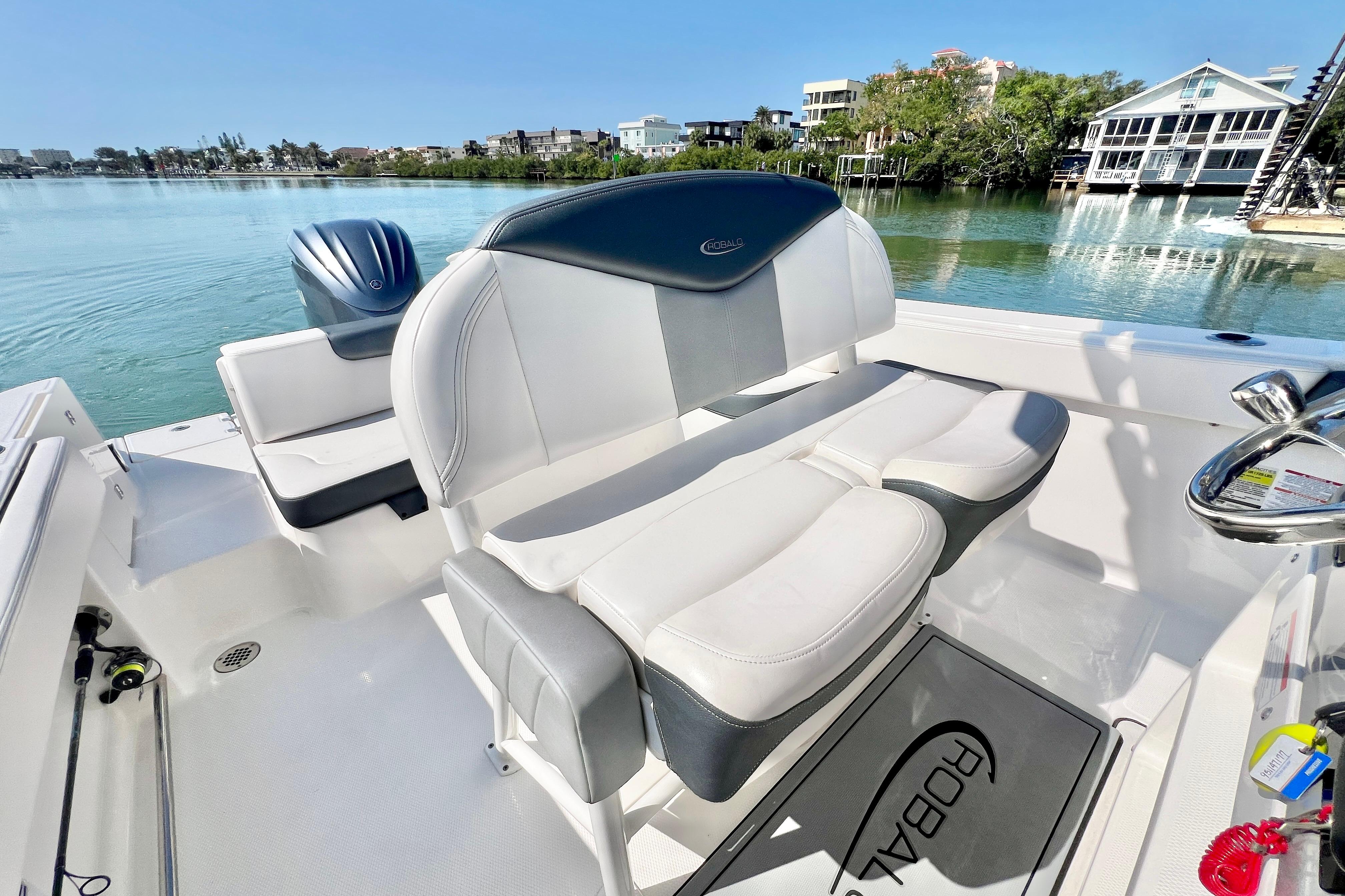 2021 Robalo R242 Explorer boat interior with seating, steering wheel, and scenic waterfront view.