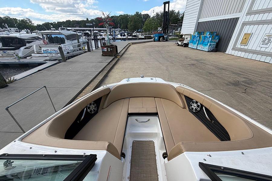 2021 Sea Ray SPX 210 boat interior at marina dock, featuring tan seating and modern design.