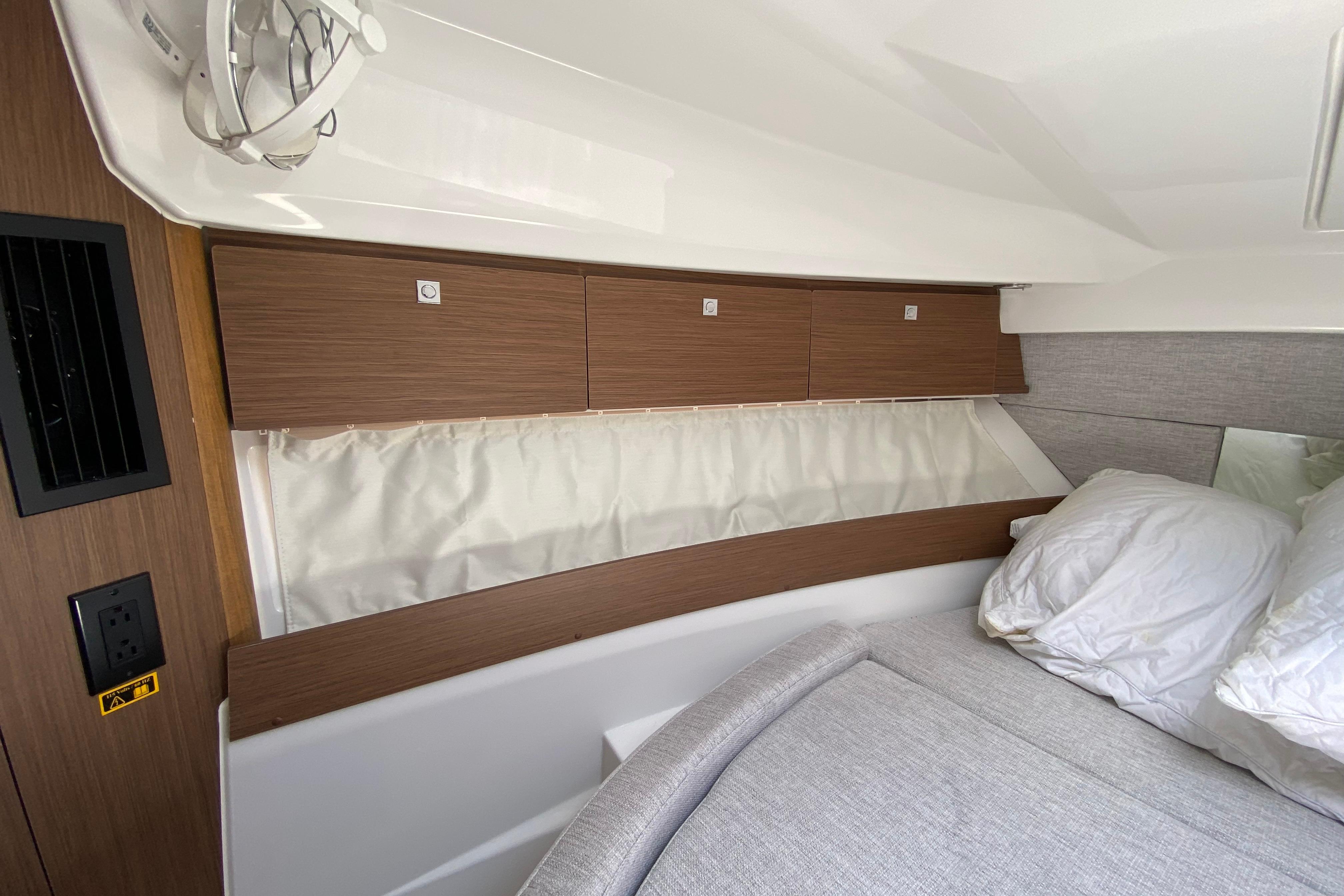 2024 Jeanneau NC Weekender 895 Series 2 cabin interior with wood paneling and cozy bedding.