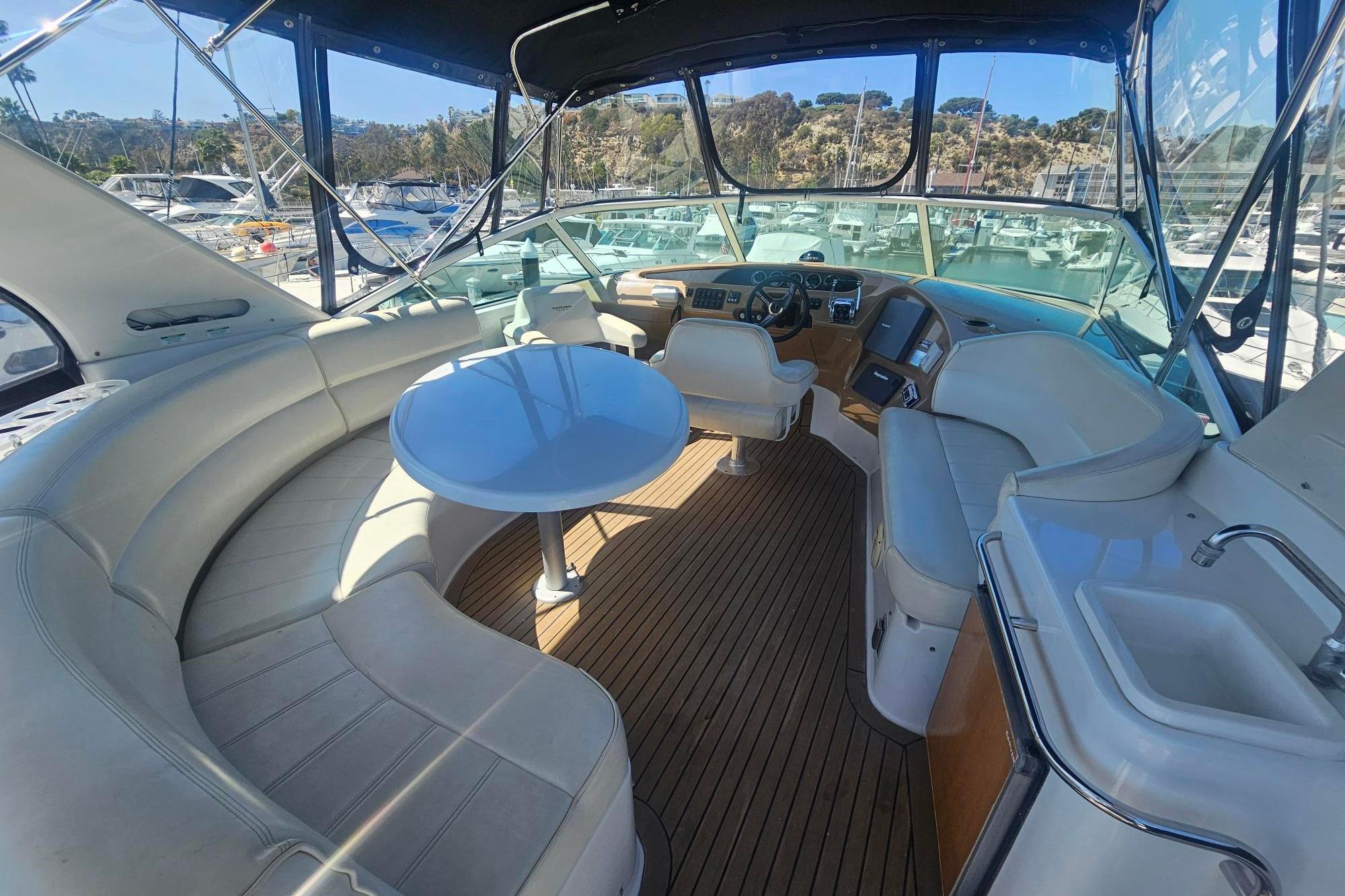 Luxurious 2002 Carver 450 Voyager Pilothouse interior with elegant seating and helm.