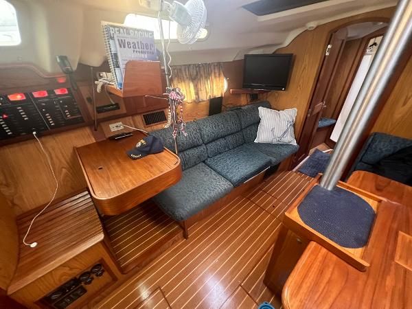 Interior of a 2000 Hunter 410 with wooden floors and blue upholstery.
