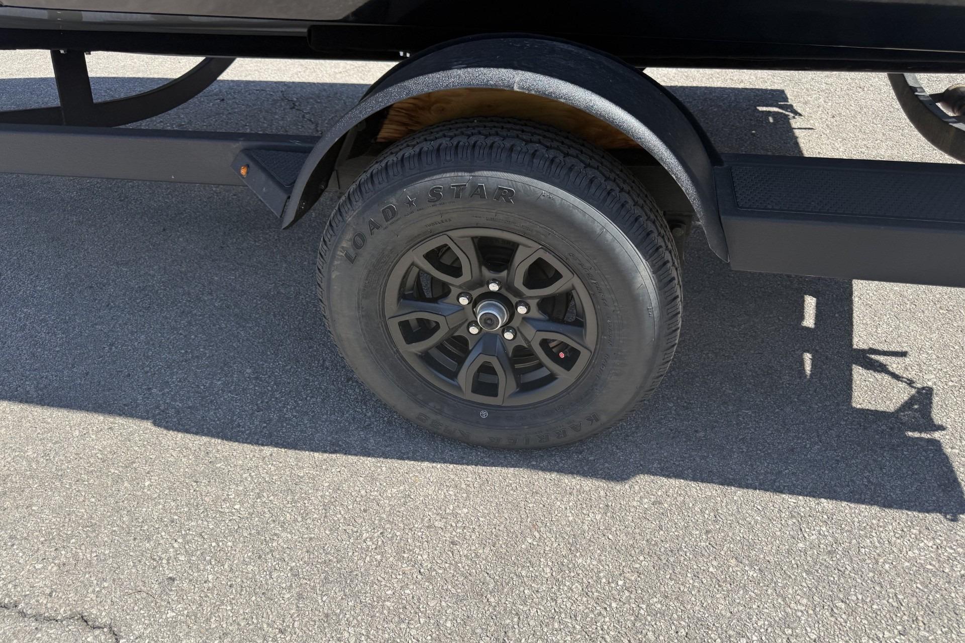 Trailer wheel of 2026 Tracker Pro Guide V-175 Combo on asphalt.
