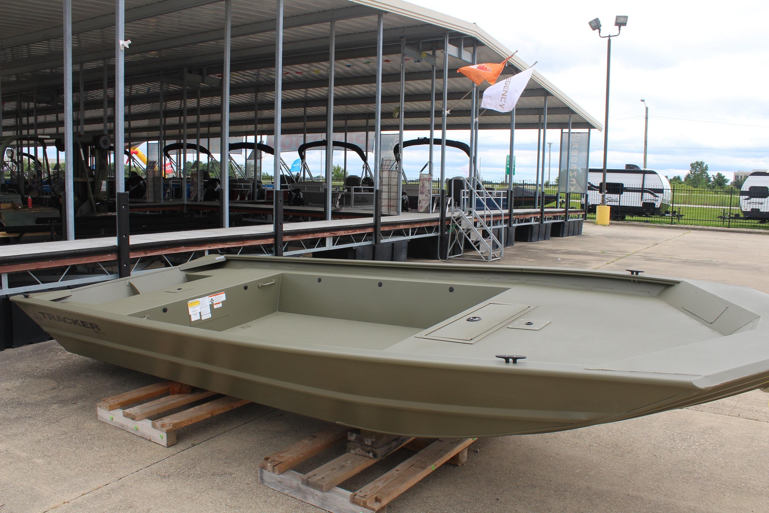 2026 Tracker Grizzly 1754 Utility boat displayed on wooden pallets at a marina.