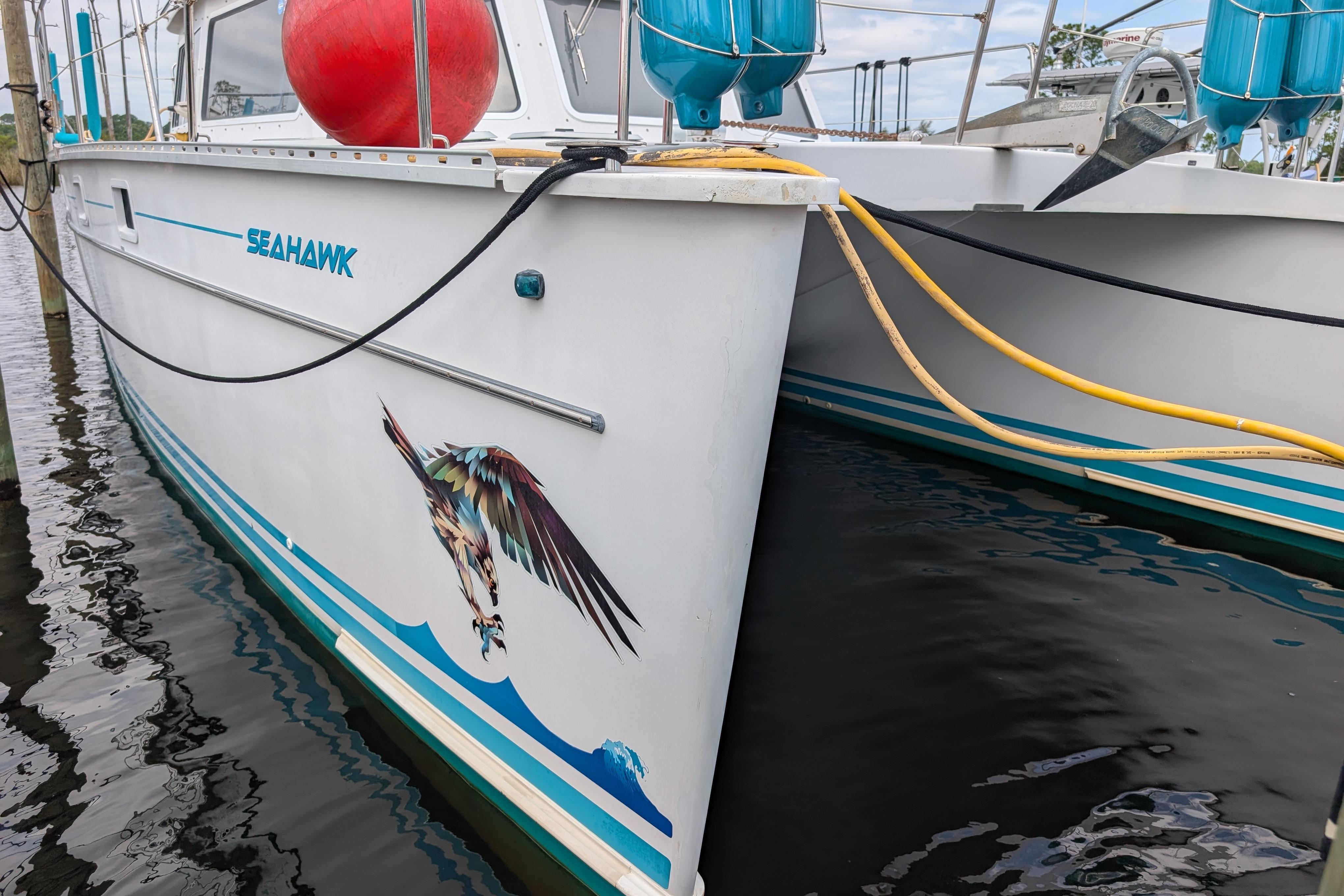 2004 PDQ 34 Powercat "Seahawk" with bird graphic, docked with visible ropes and fenders.