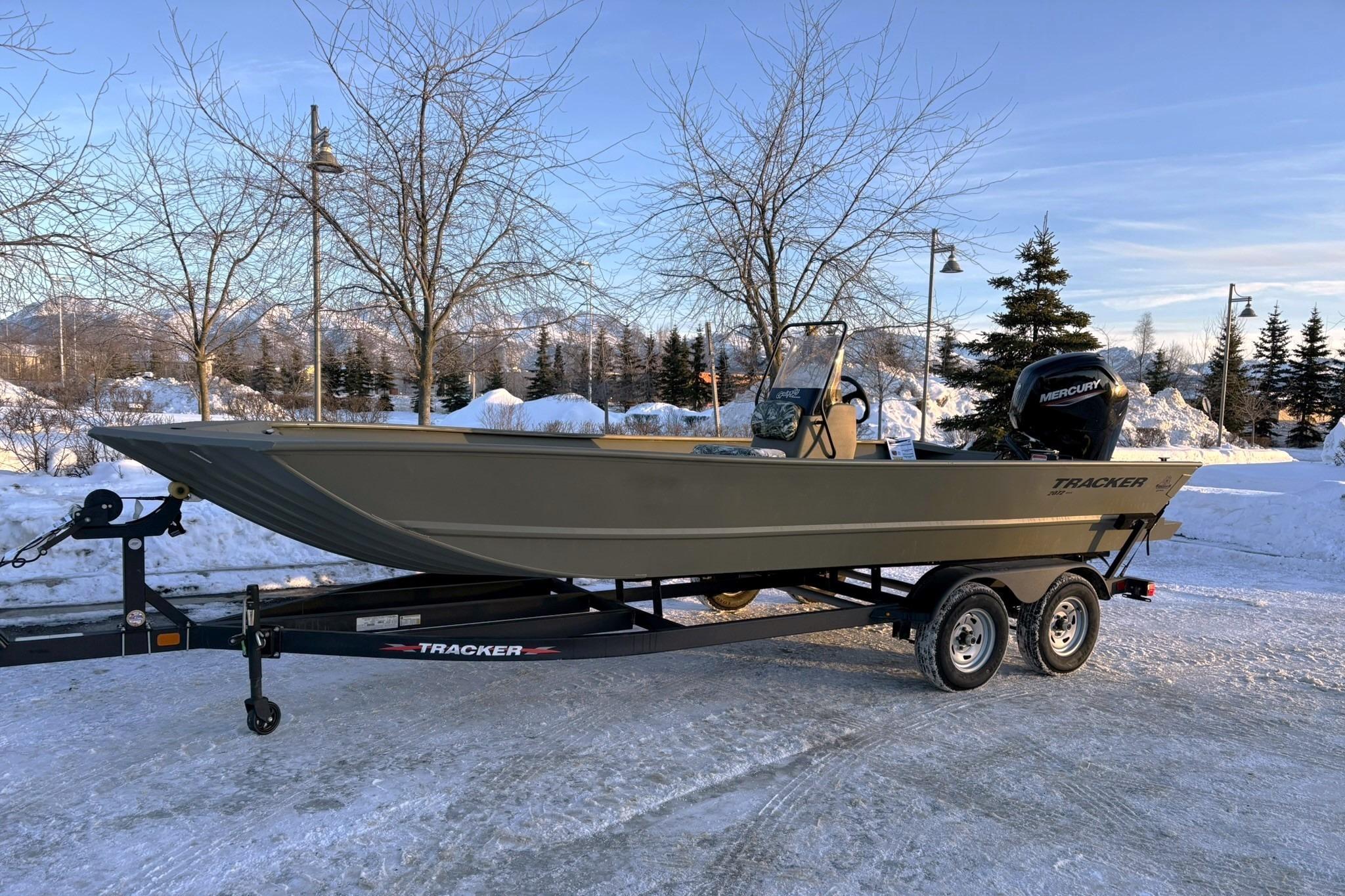 2024 Tracker Grizzly 2072 CC boat on trailer in snowy landscape.
