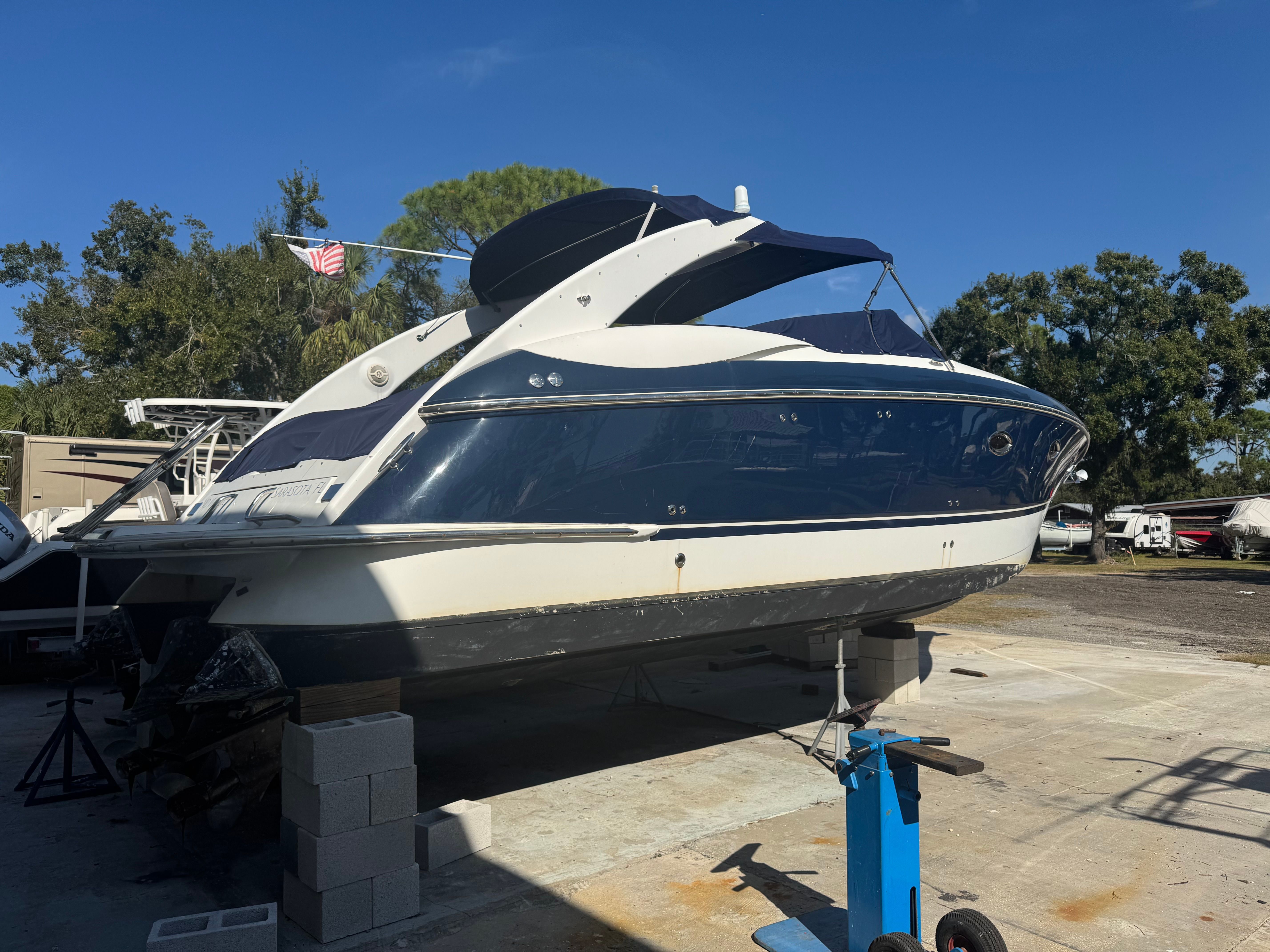 A 2003 Cobalt 360 is on blocks. It features a blue and white design.