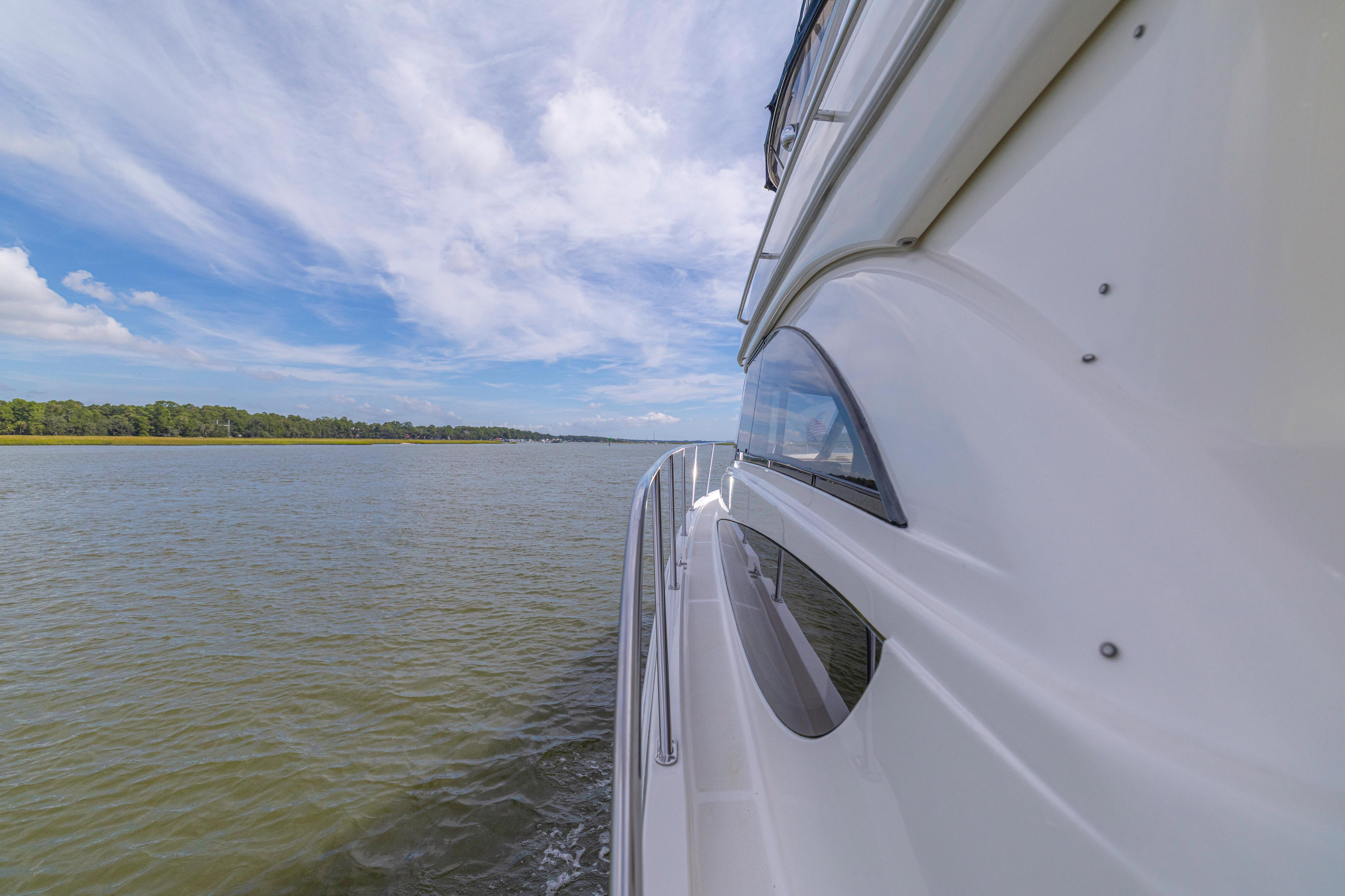 Side view of 2006 Meridian 341 Sedan yacht cruising on a calm river.