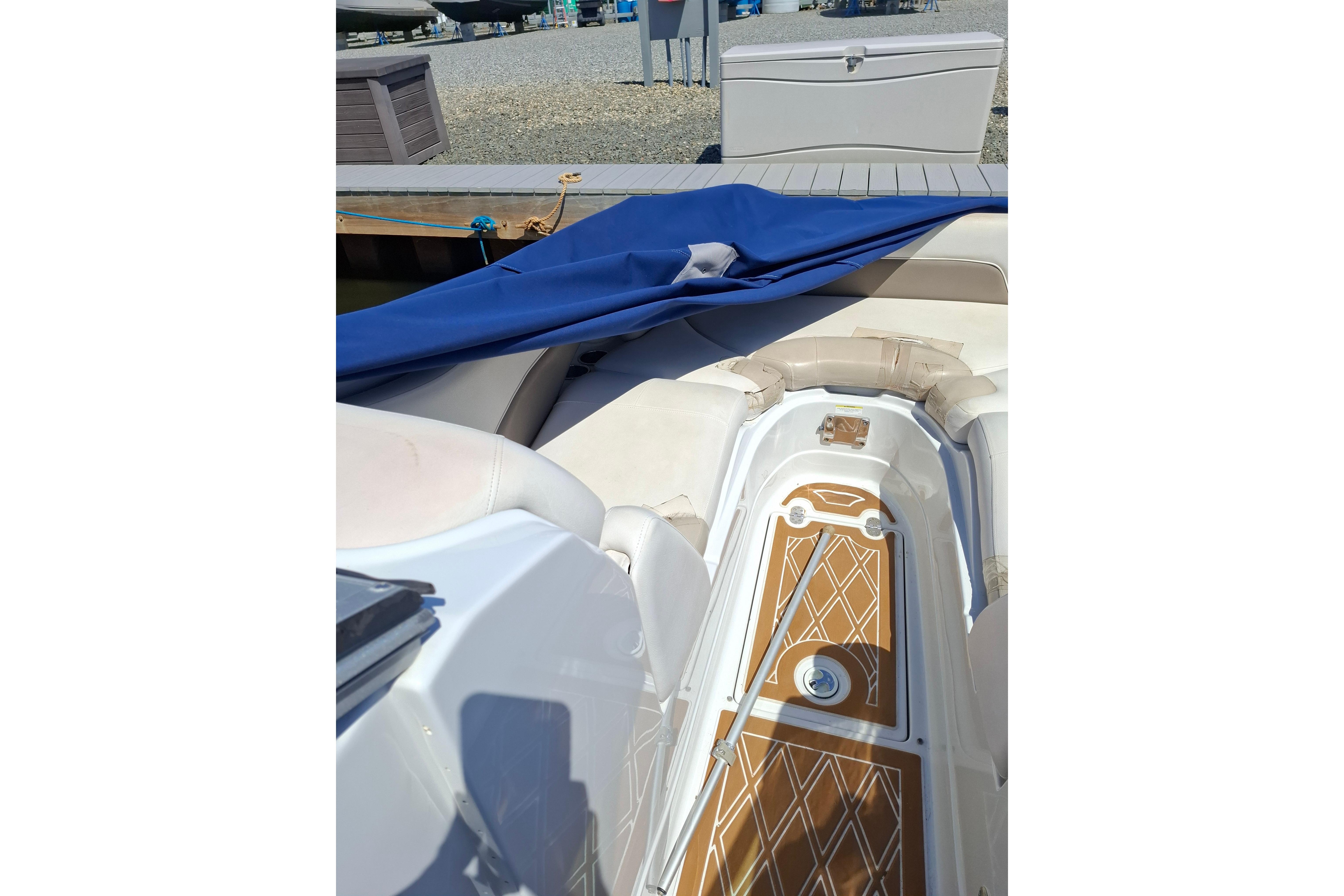 2013 Crownline Eclipse E6 boat interior with blue cover and cushioned seating.