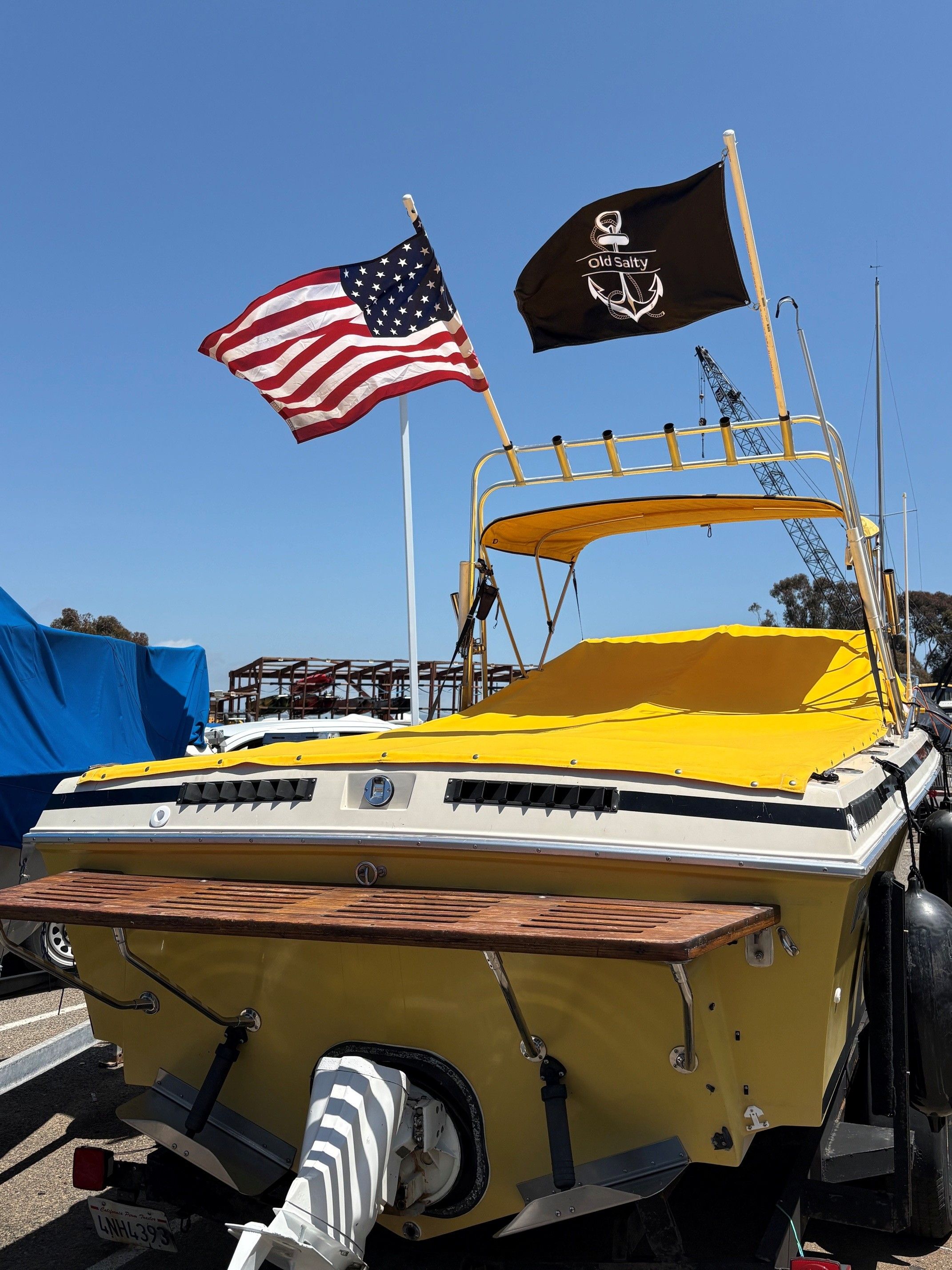 1979 Wellcraft Nova 250 boat with yellow cover and flags.