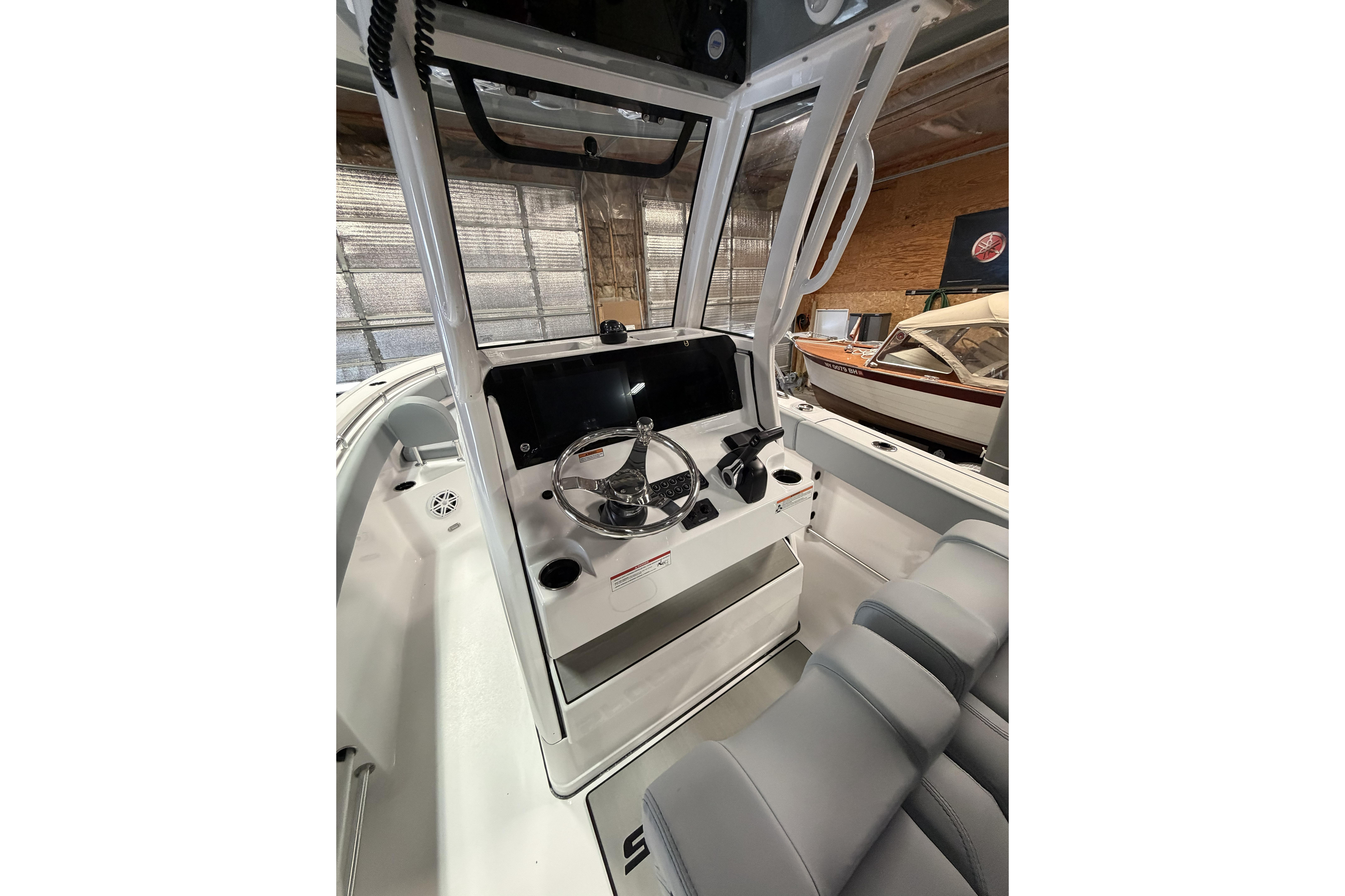 2026 Sportsman Open 232 Center Console boat interior with steering wheel and seating.