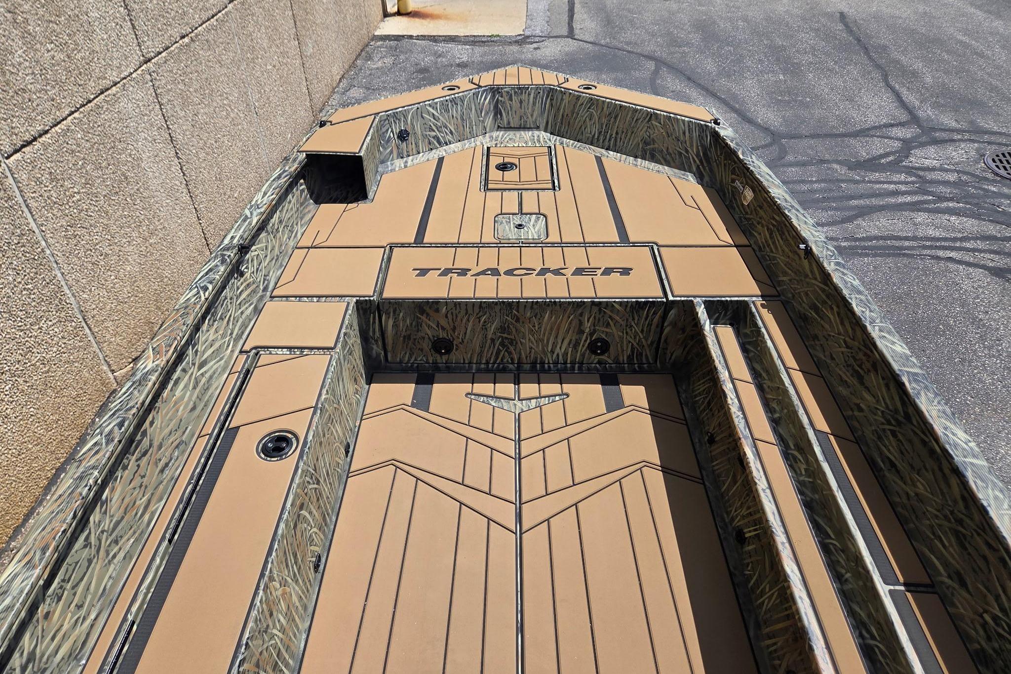 2026 Tracker Grizzly 1756 T Marsh boat with camo design, parked on pavement.