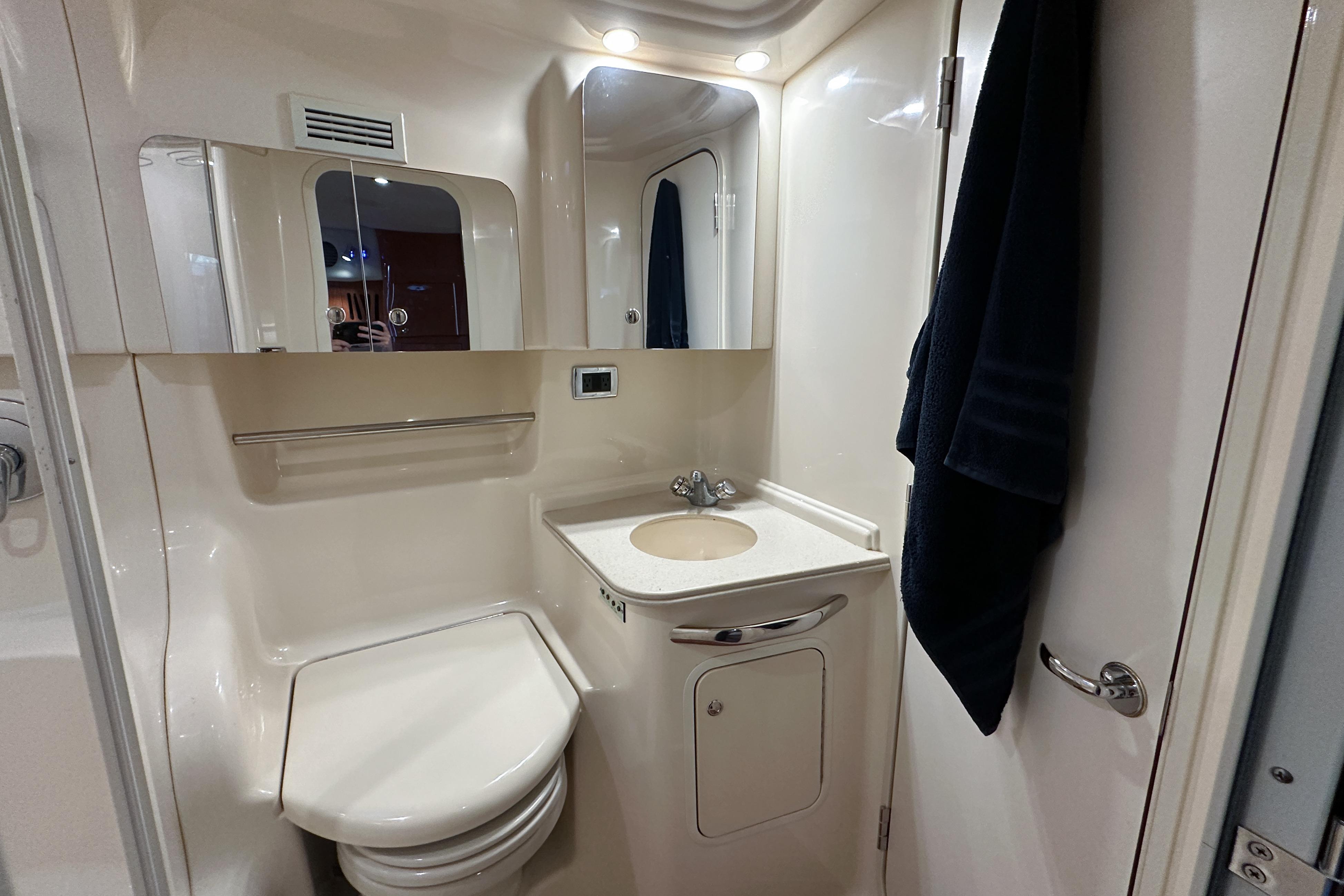 Bathroom interior of 2001 Sea Ray 410 Sundancer yacht, featuring sink and toilet.