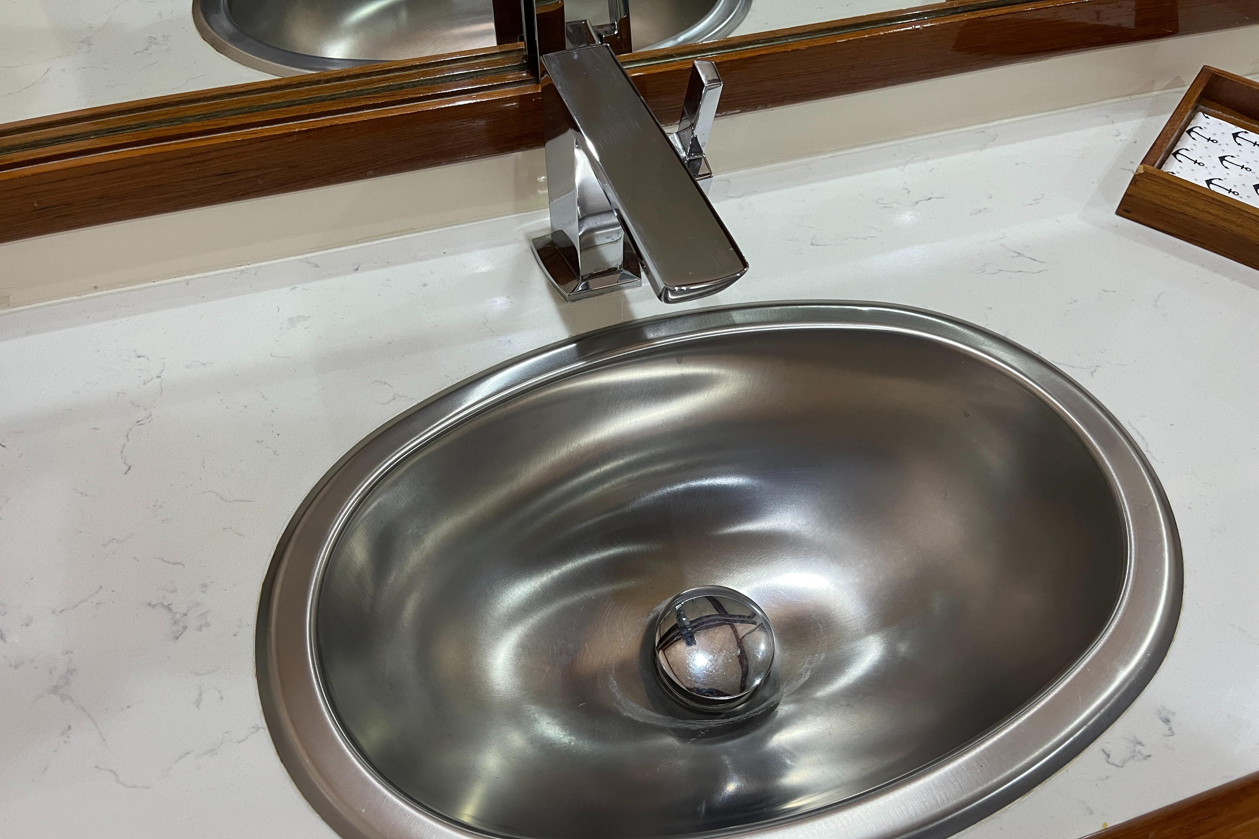 Stainless steel sink with modern faucet on Mikelson 1999 luxury sportfisher yacht.