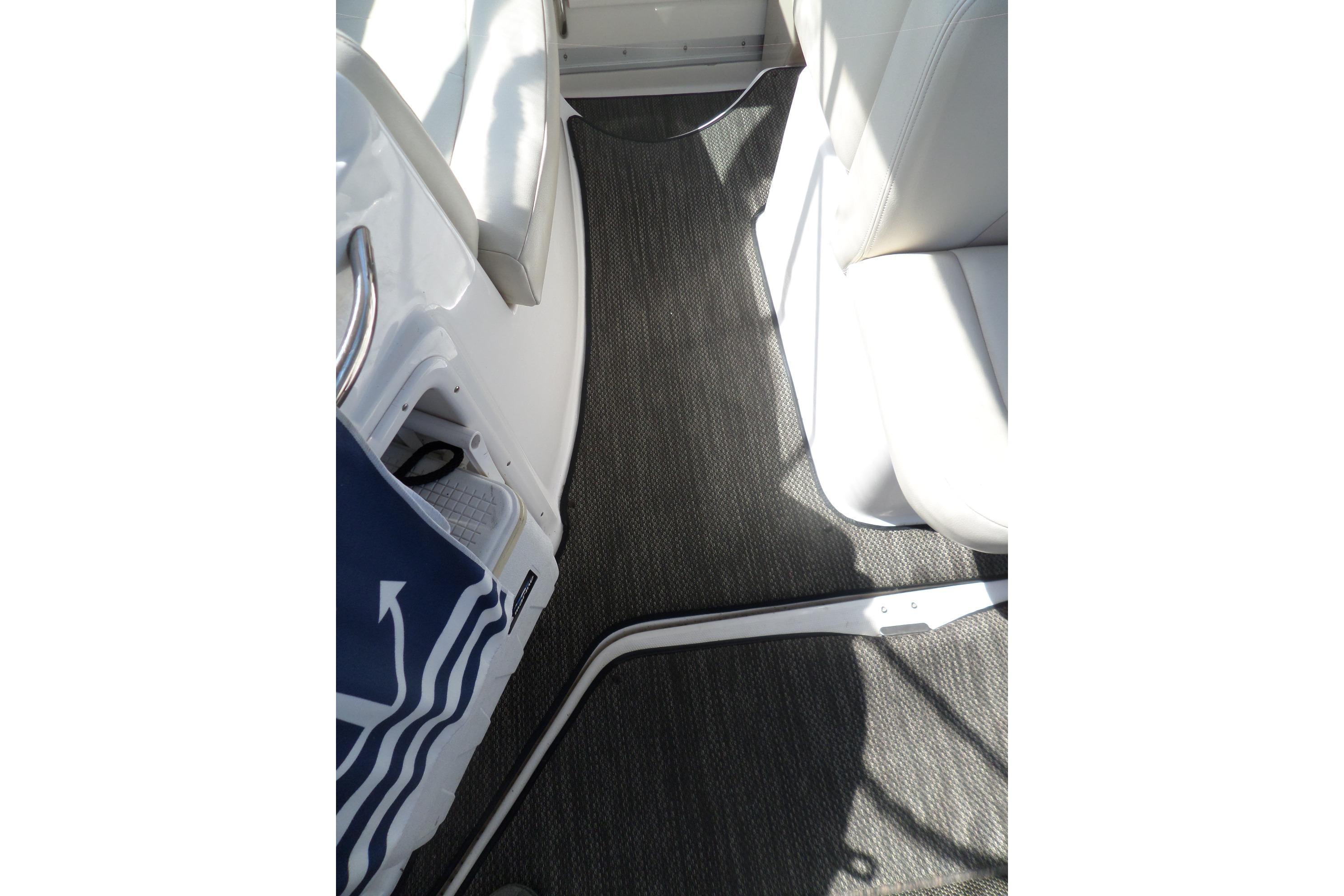 Interior view of 2005 Chaparral Signature 270 boat with carpeted flooring and seating.