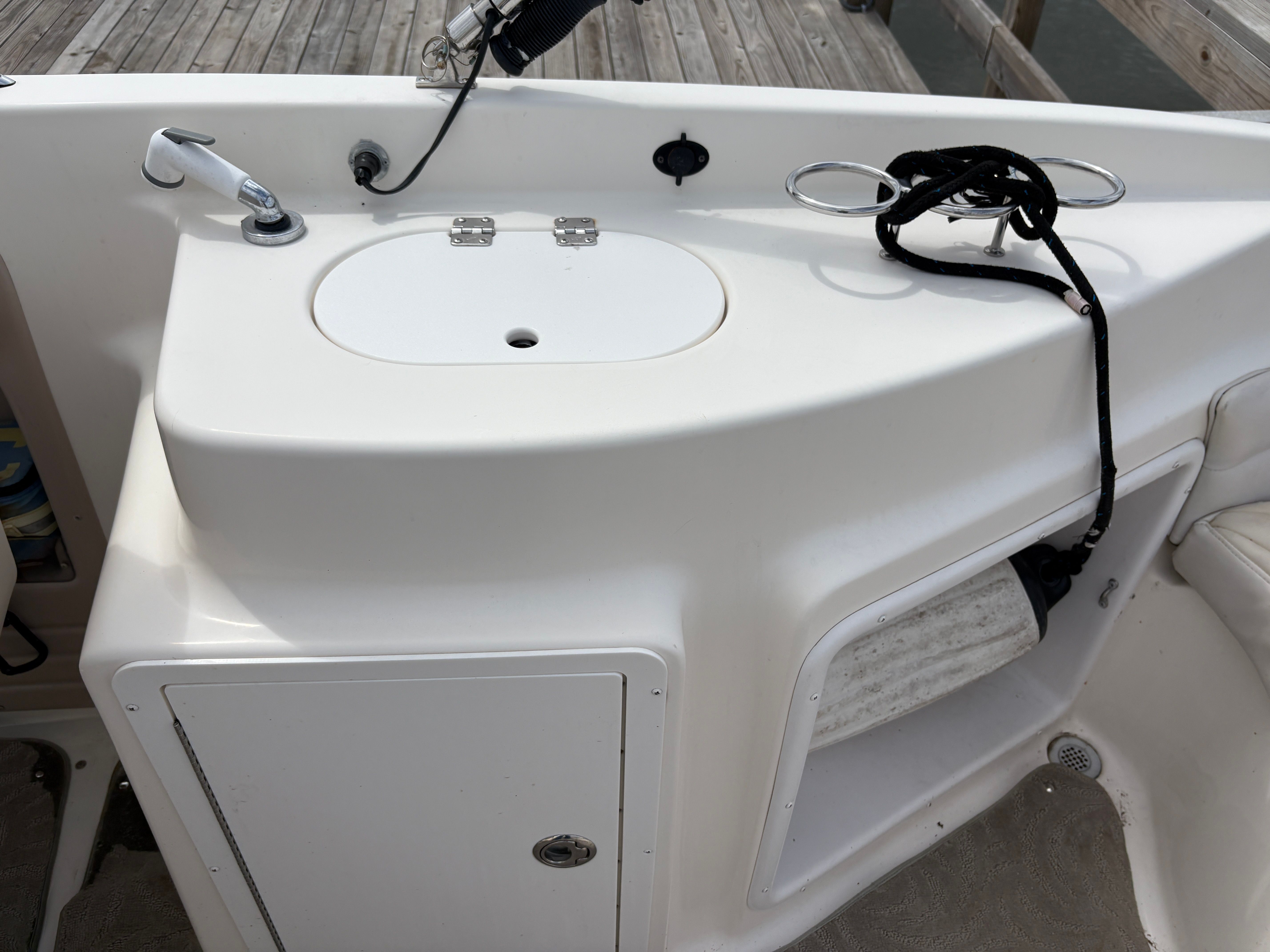 2009 Hurricane SUN DECK 260 boat kitchenette with sink and storage.