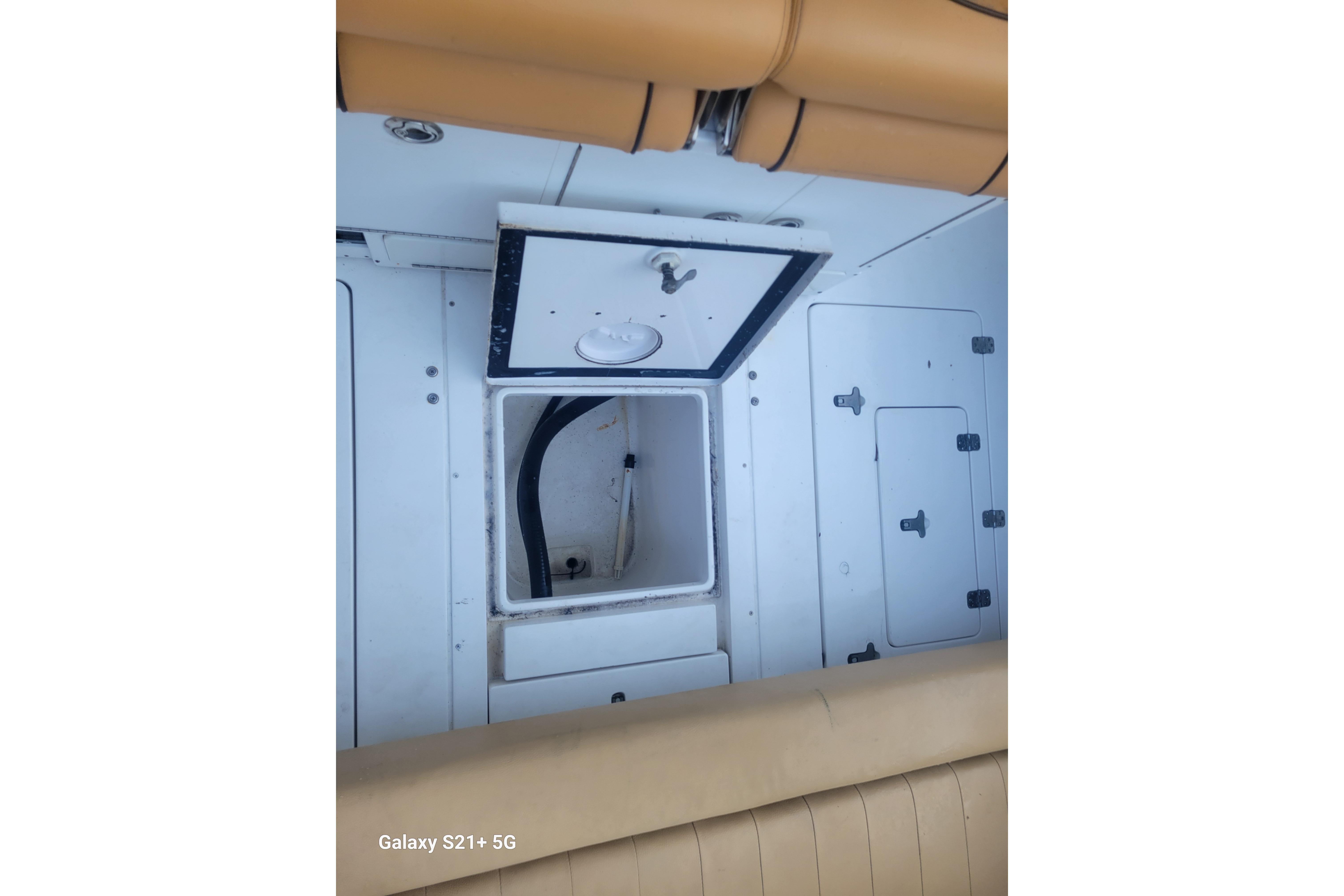2005 Intrepid 323 Cuddy interior storage compartments with tan seating.