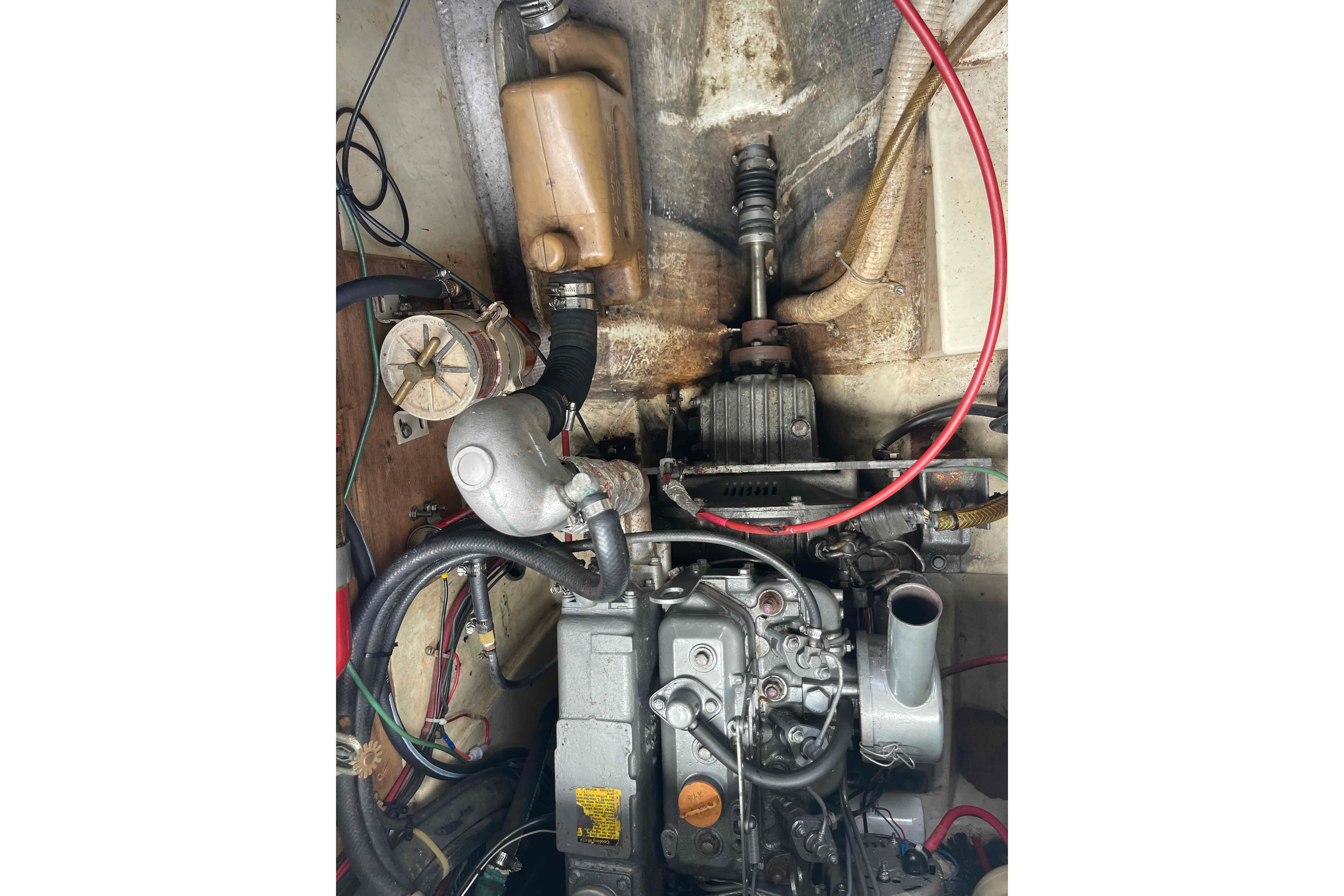 Engine compartment of a 1987 Pacific Seacraft 34 sailboat, showing mechanical components and wiring.