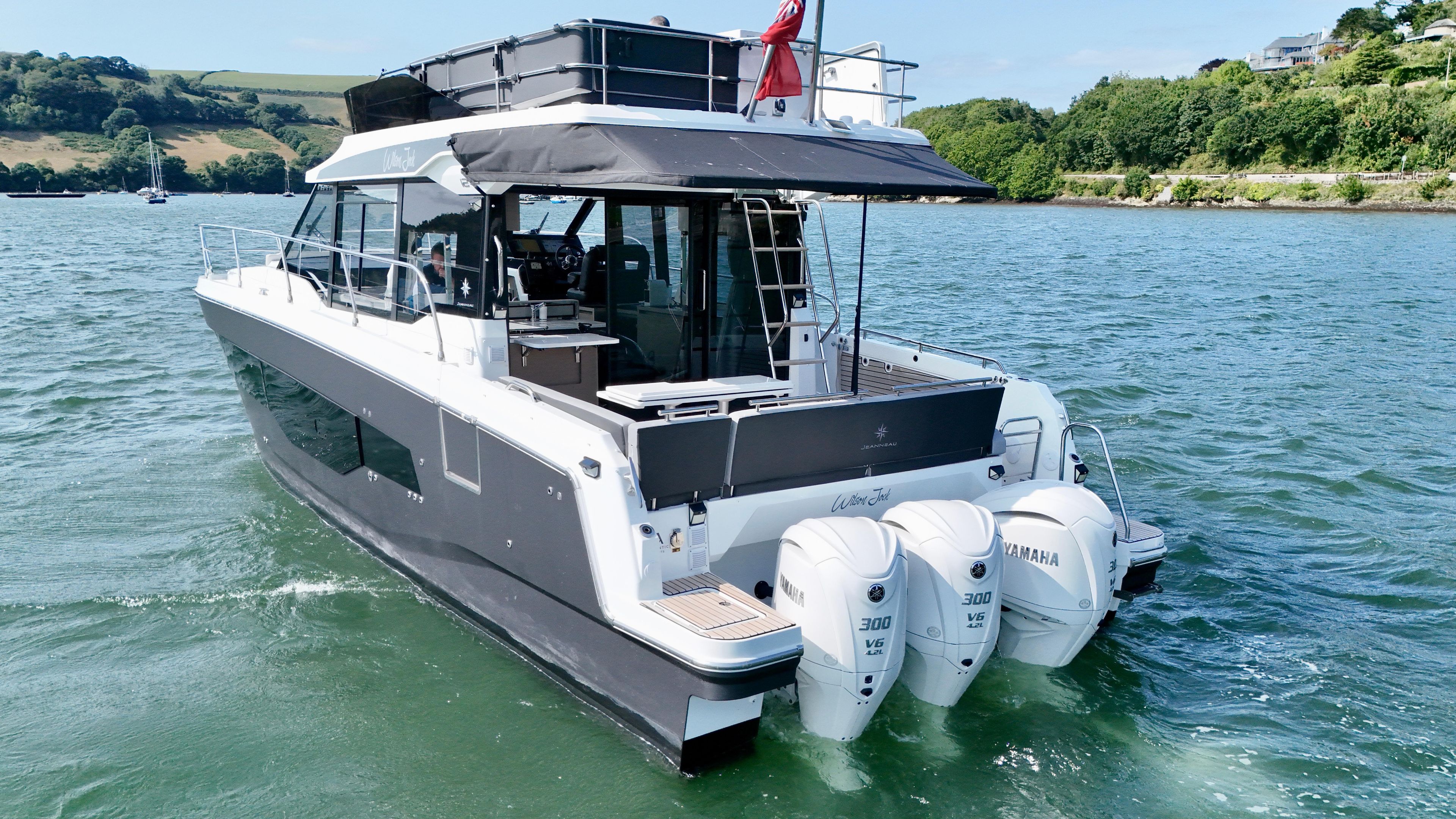 2024 Jeanneau Merry Fisher 1295 Flybridge yacht on water, featuring triple Yamaha engines.