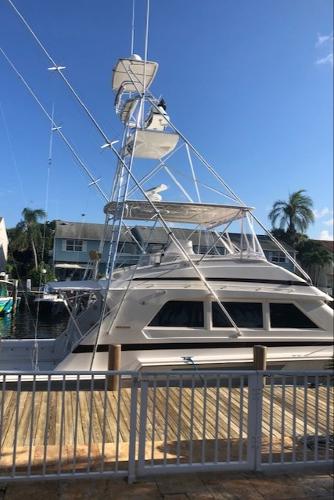 1997 Bertram Convertible yacht docked at a marina on a sunny day.