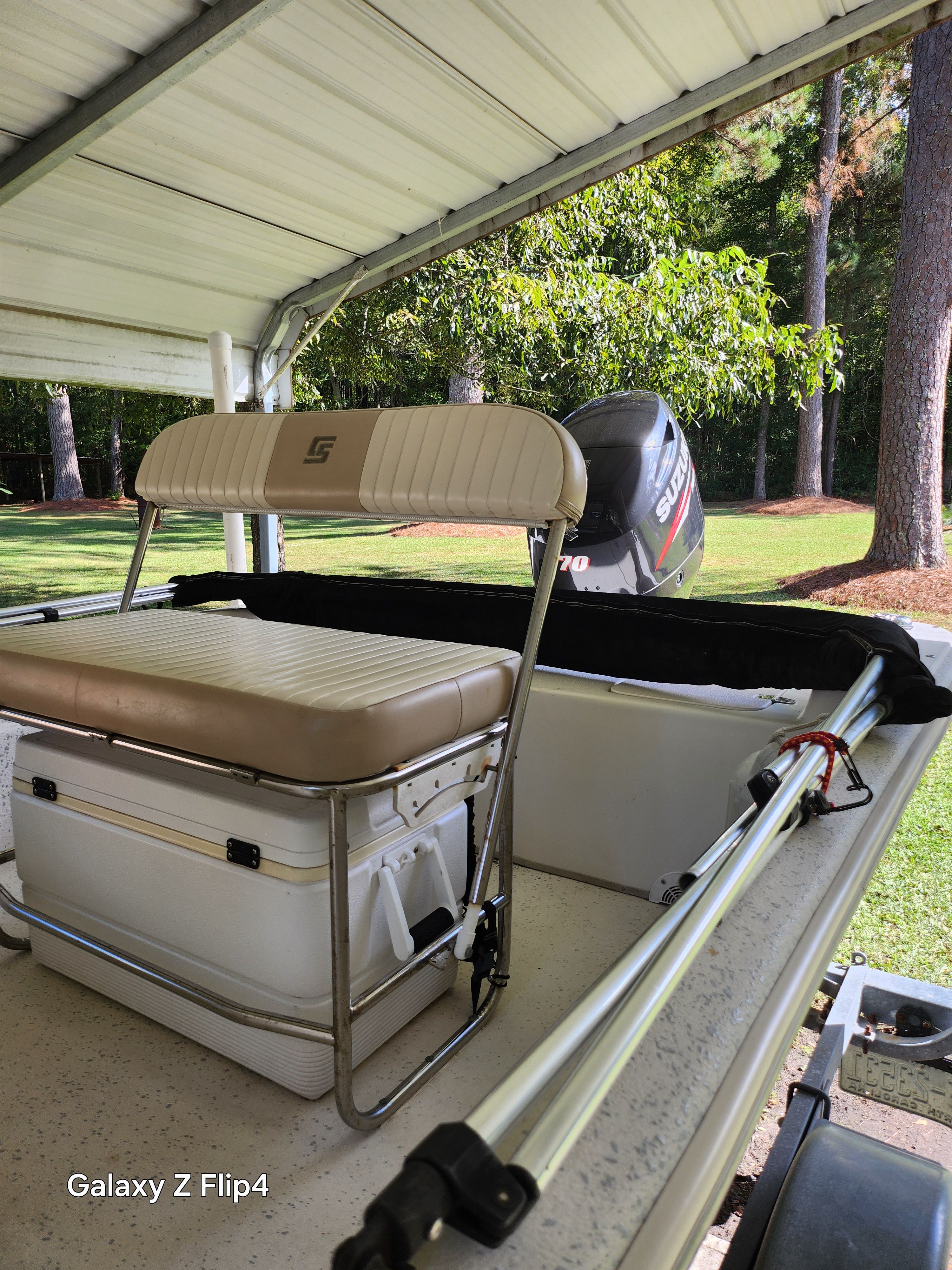2013 Carolina Skiff JVX18CC boat under shelter with Suzuki outboard motor.