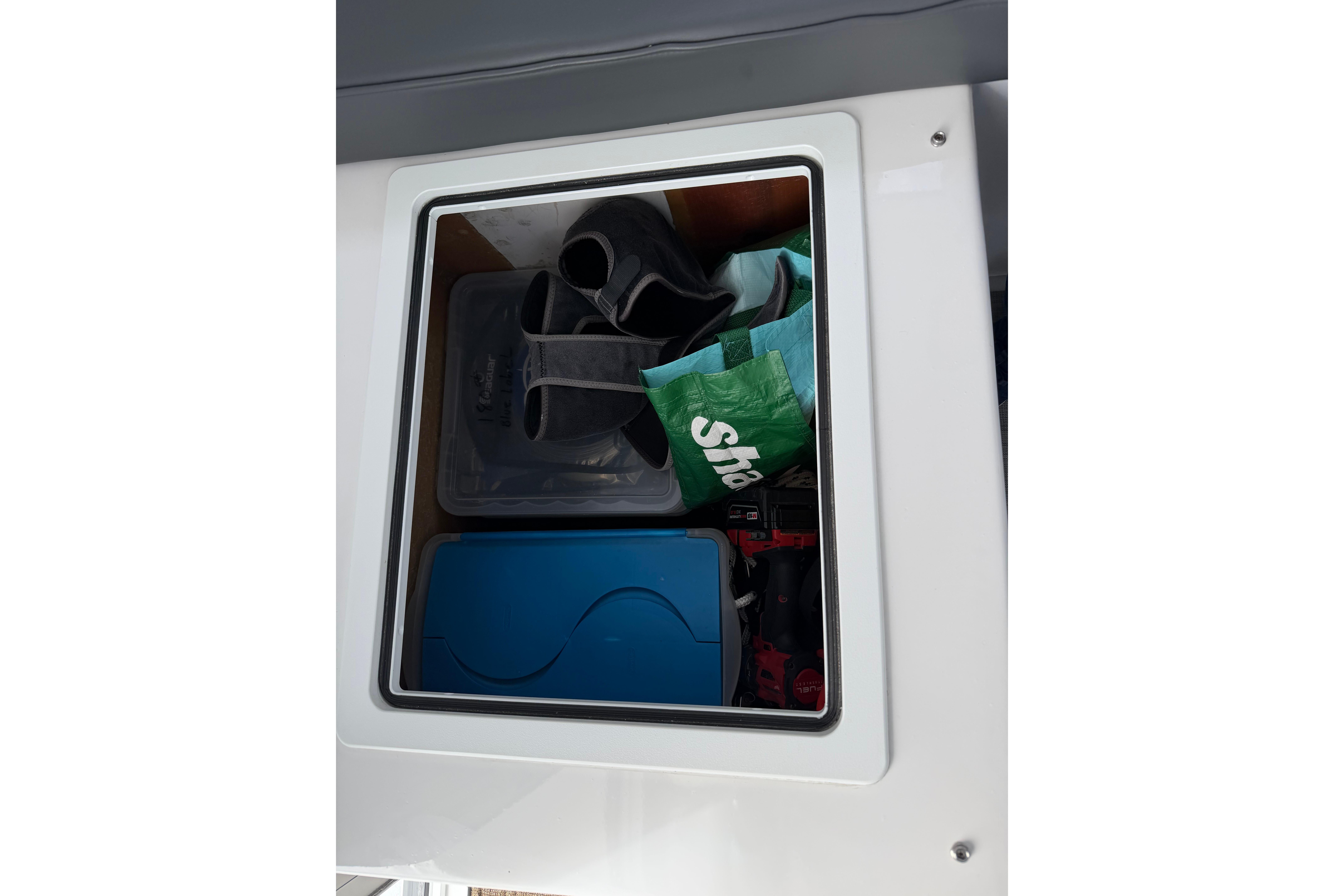 Storage compartment on 2018 H&H Marine Osmond Beal boat with various items inside.