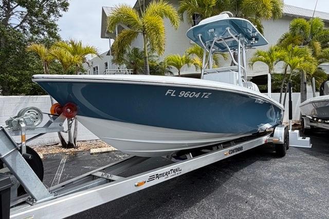 2025 Contender 26 Bay boat on trailer, parked outdoors with palm trees in background.