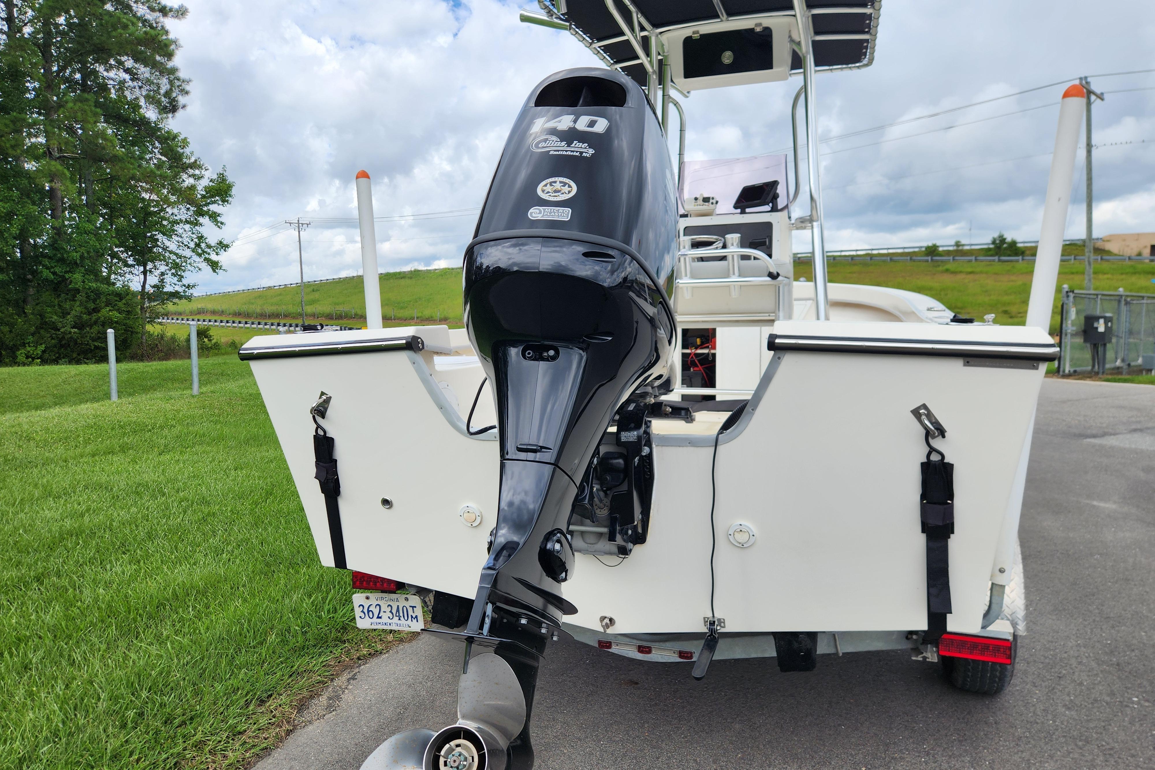 2023 May-Craft 1900CC boat with powerful outboard motor, parked on a grassy area.