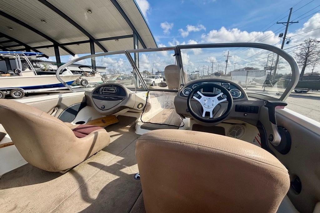 2008 Ranger 180 Reata boat interior with steering wheel and dashboard under a sunny sky.