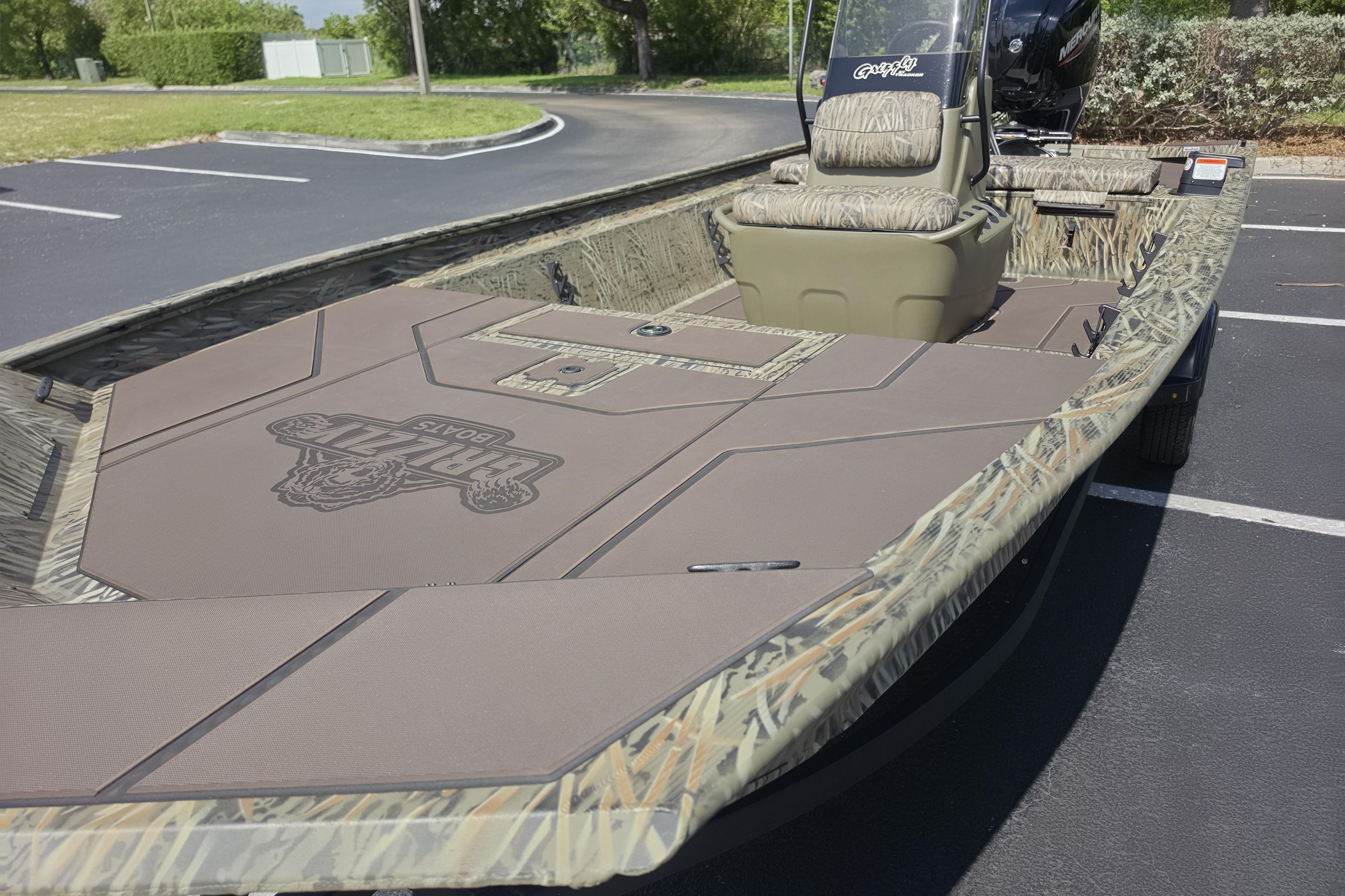 2026 Tracker Grizzly 1860 CC boat with camouflage design in a parking lot.