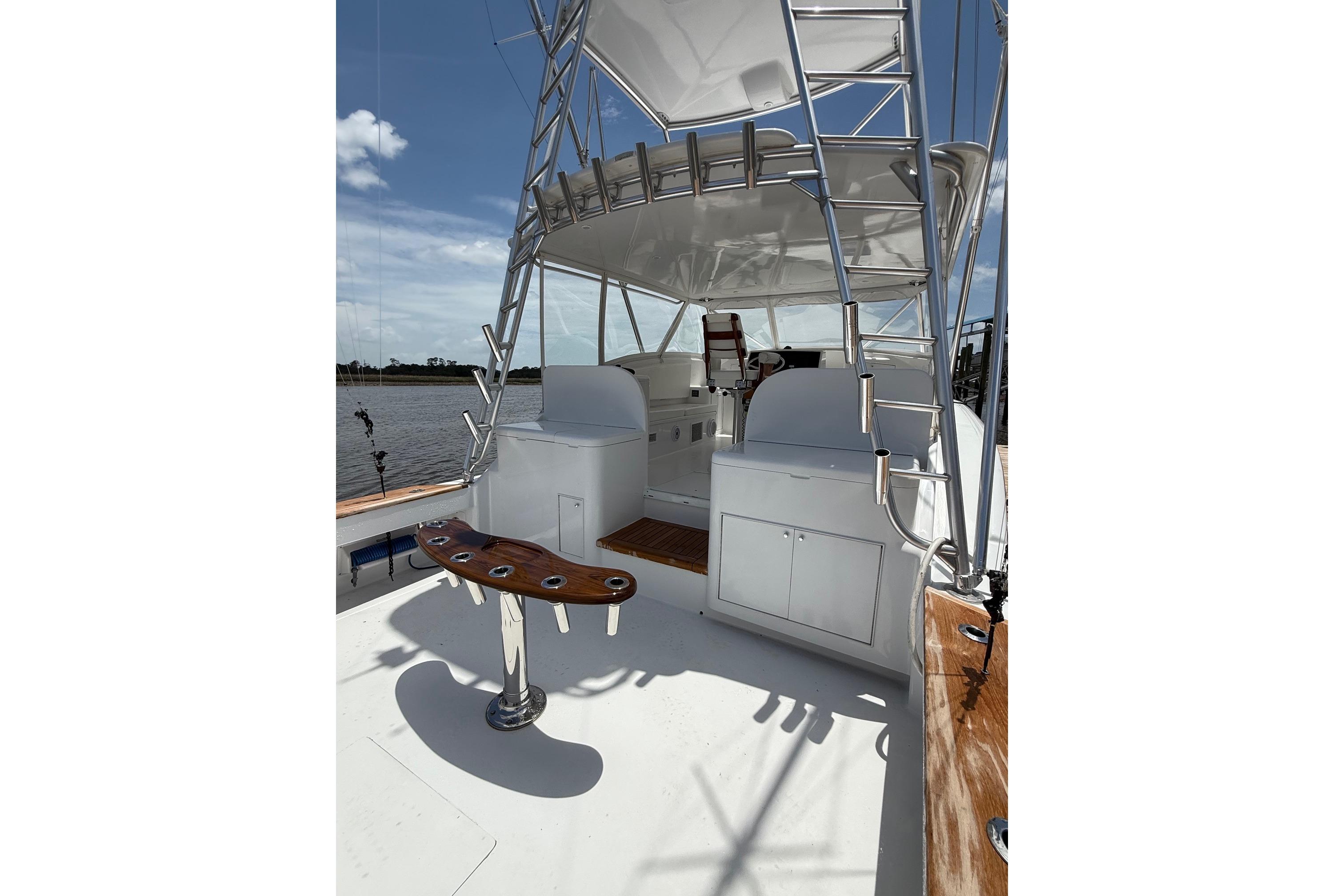 2006 Custom Carolina Heritage Express boat with tower, rod holders, and helm station on deck.
