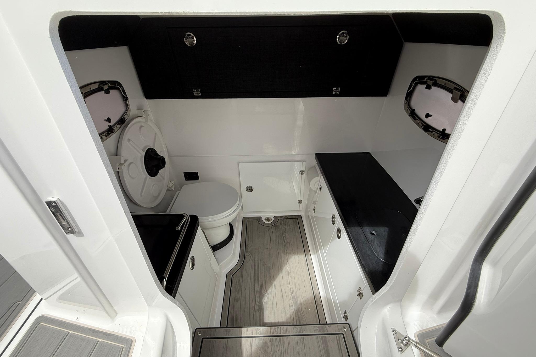 Interior of 2027 Monterey Elite 30 OB boat featuring a compact bathroom with modern amenities.