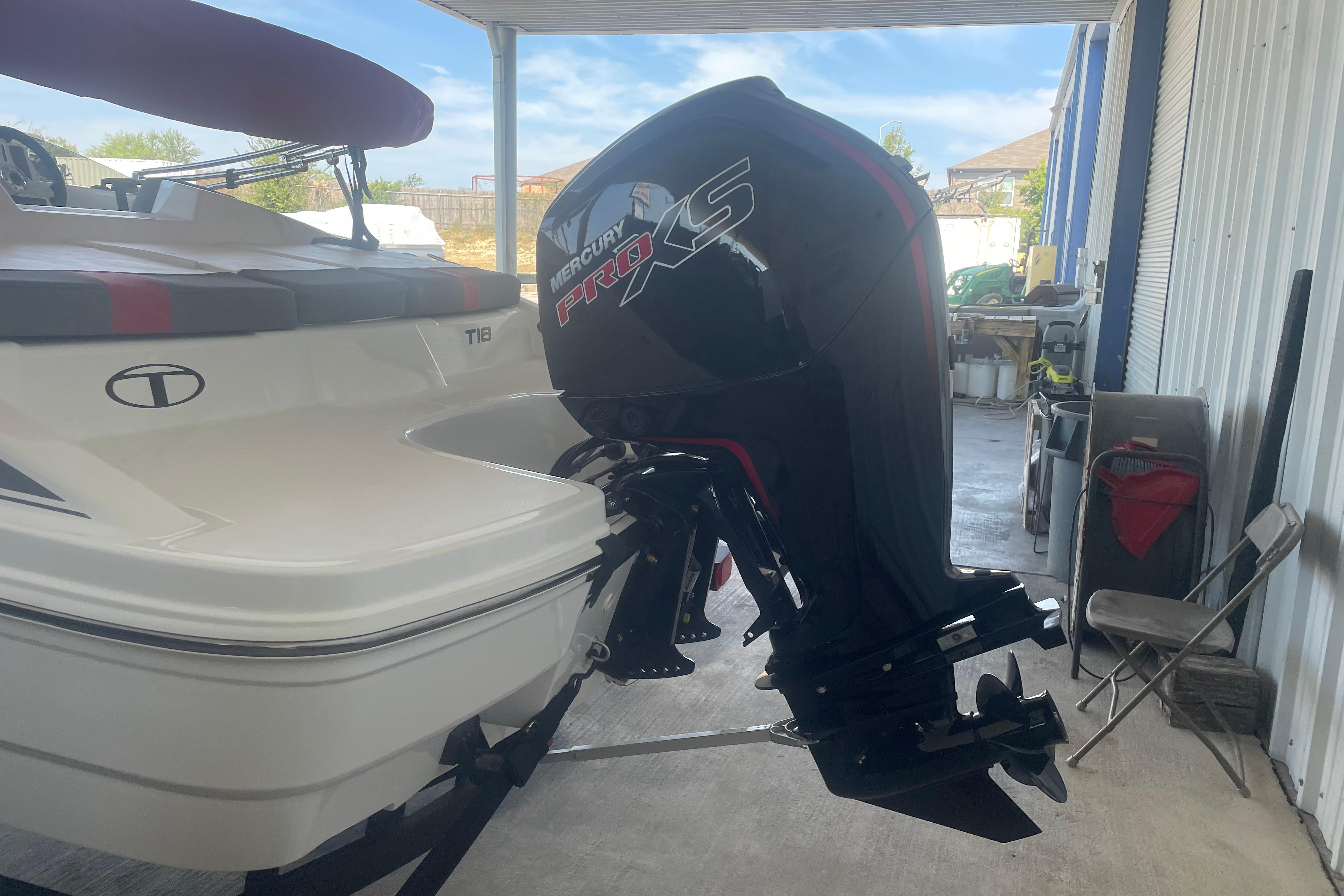 2026 Tahoe T18 boat with Mercury Pro XS outboard motor in a garage.