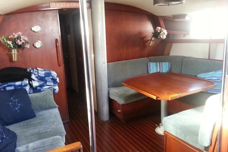 1977 Morgan Out Island 51 yacht interior with cozy seating and wooden table.