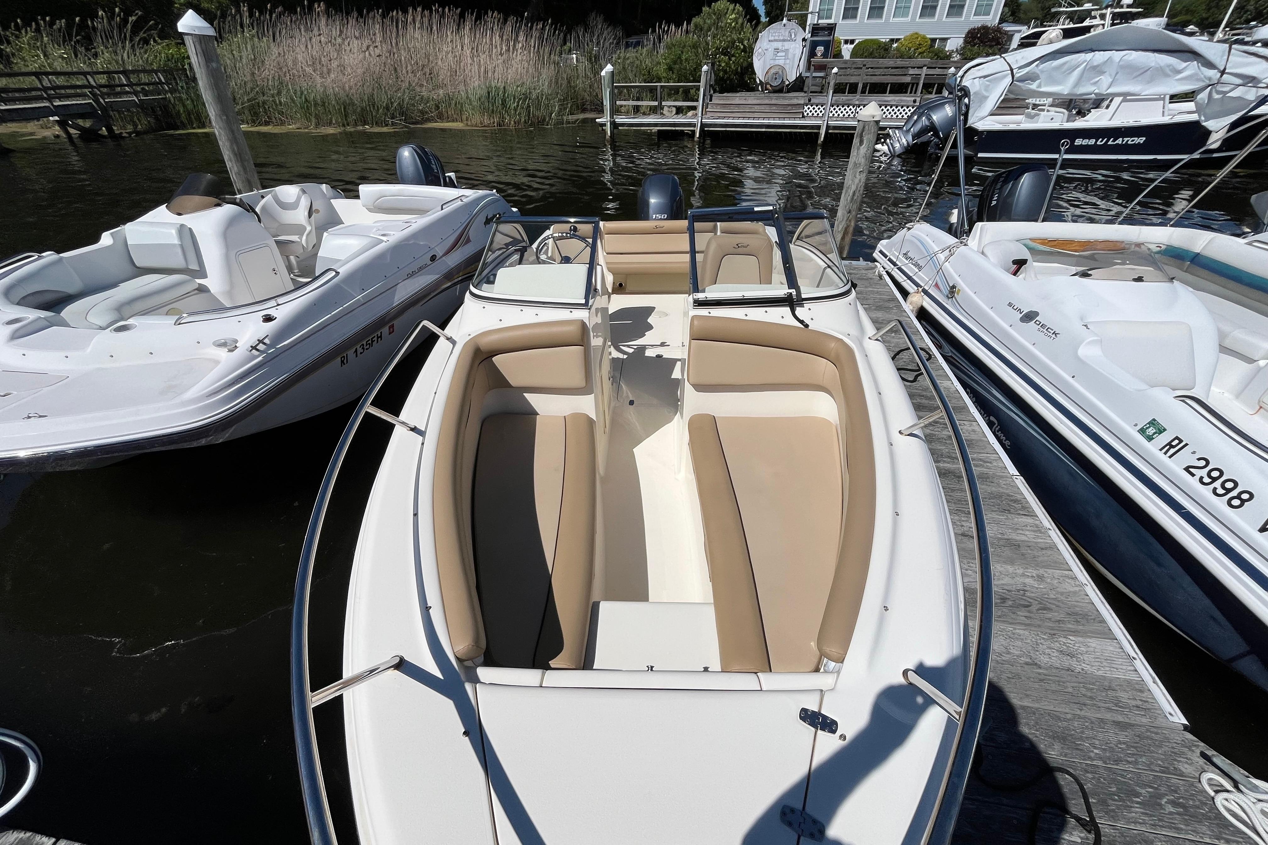 2017 Scout 210 Dorado boat docked, featuring beige seating and sleek design.