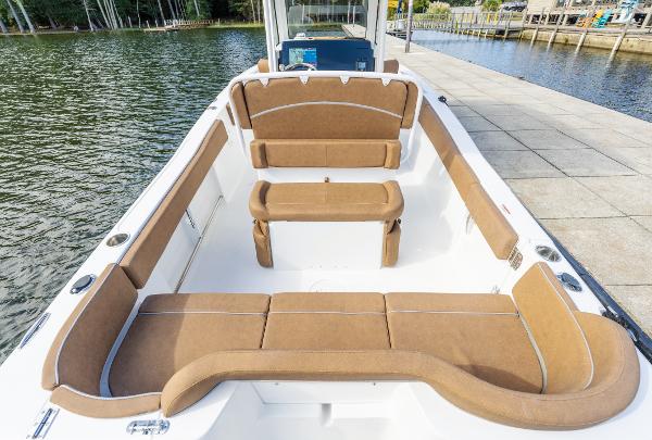2025 Sea Hunt Ultra 235 SE boat interior with tan seating, docked by the water.