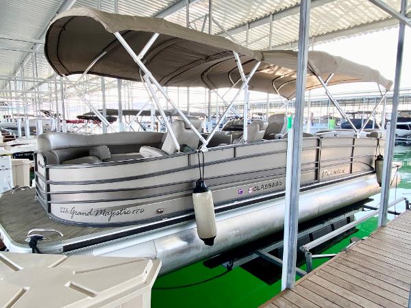 A 2011 Premier 275 Grand Majestic PTX pontoon boat in a covered dock.