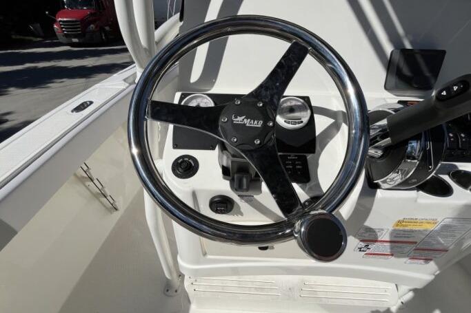 Steering wheel of 2025 Mako 214 Center Console boat, featuring modern controls and gauges.