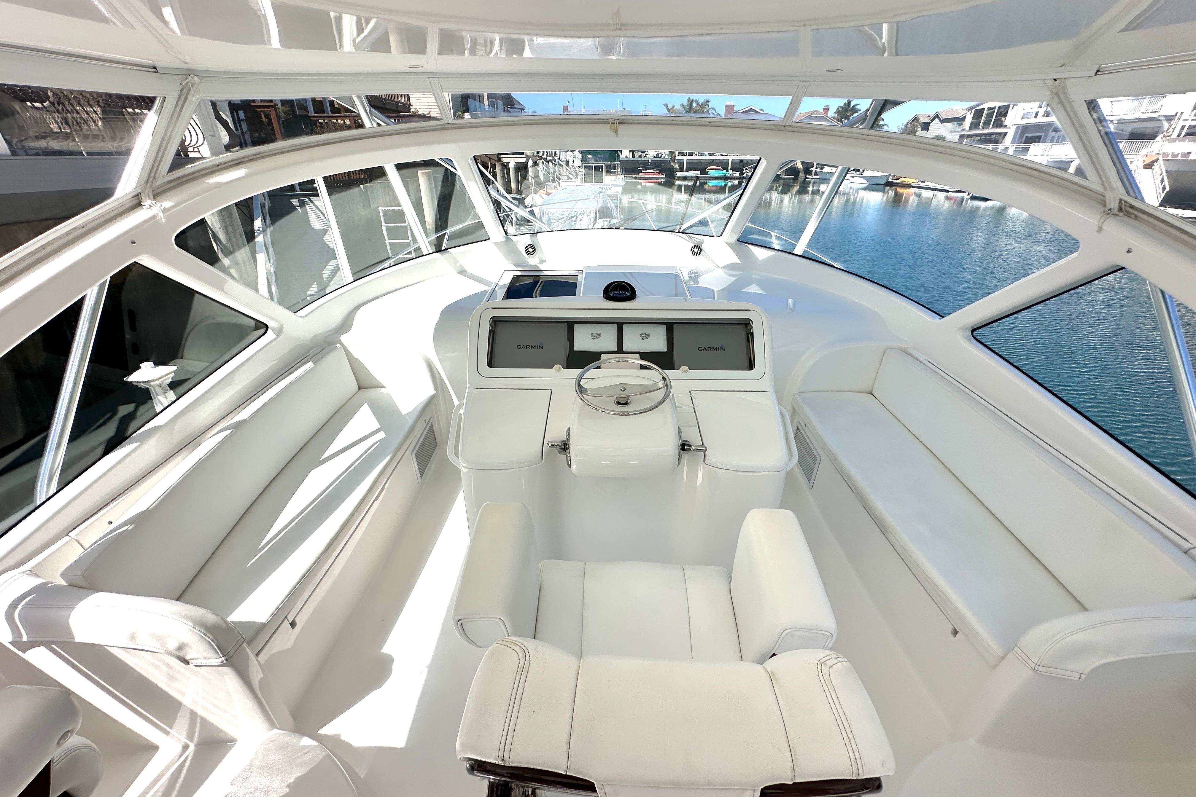 2012 Viking 42 Open yacht helm with white seating and panoramic windows.