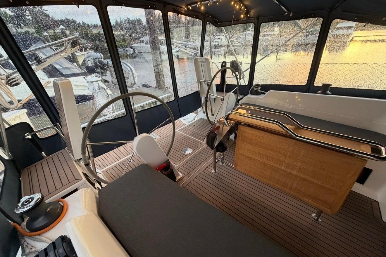 Interior of 2022 Hanse 418 yacht with dual steering wheels and elegant wood finish.
