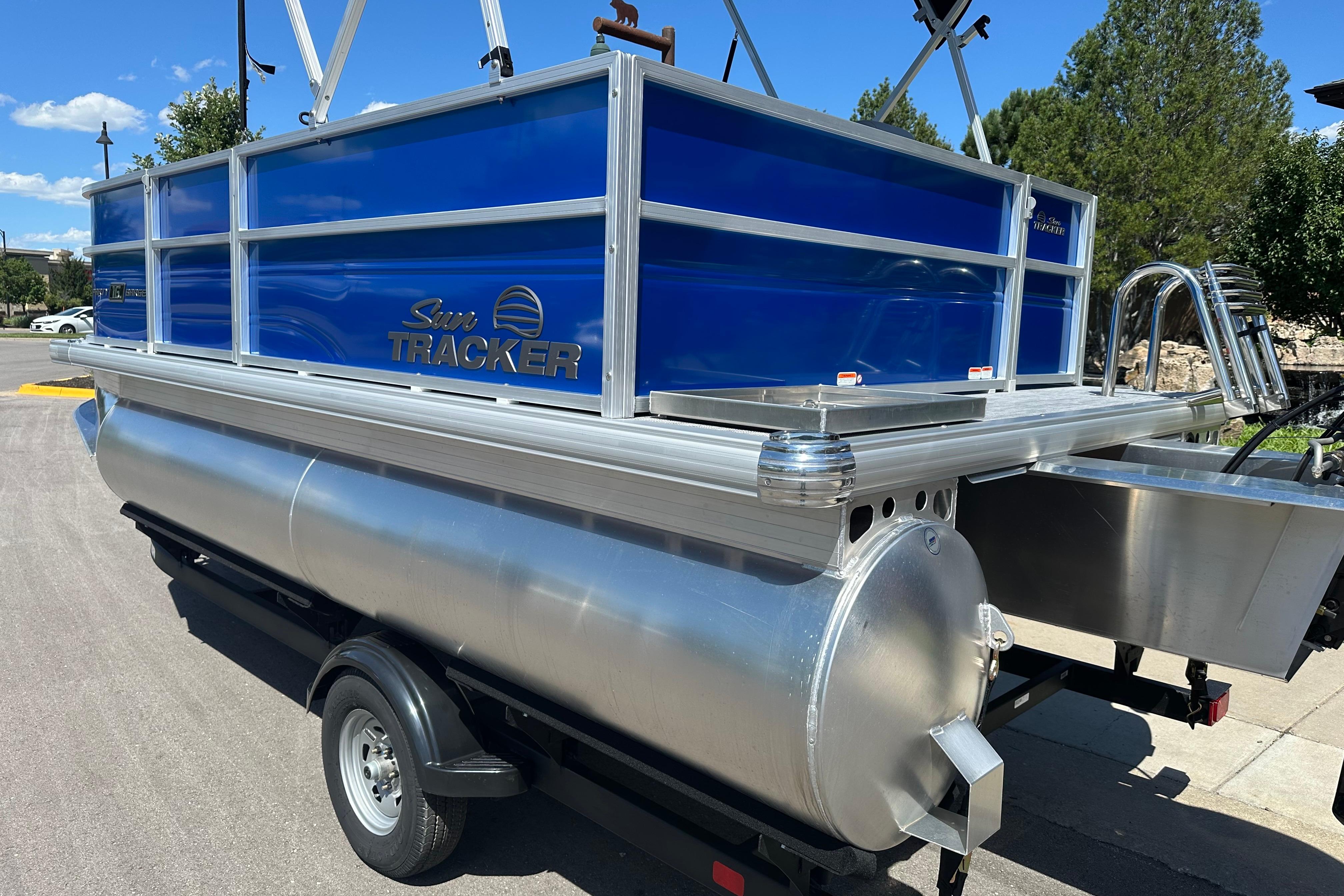 2026 Sun Tracker Party Barge 16 DLX pontoon boat with blue exterior on trailer.